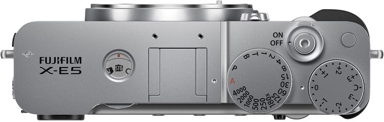 Felülnézet egy ezüst Fujifilm X-E5 kameráról. Tárcsák és gombok láthatók, beleértve az ISO, a záridő és az expozíció-kompenzáció beállításait.