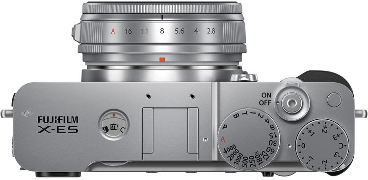 Felülnézet egy ezüst Fujifilm X-E5 fényképezőgépről. Az objektíven rekeszbeállítások találhatók. A testen beállító tárcsák vannak.