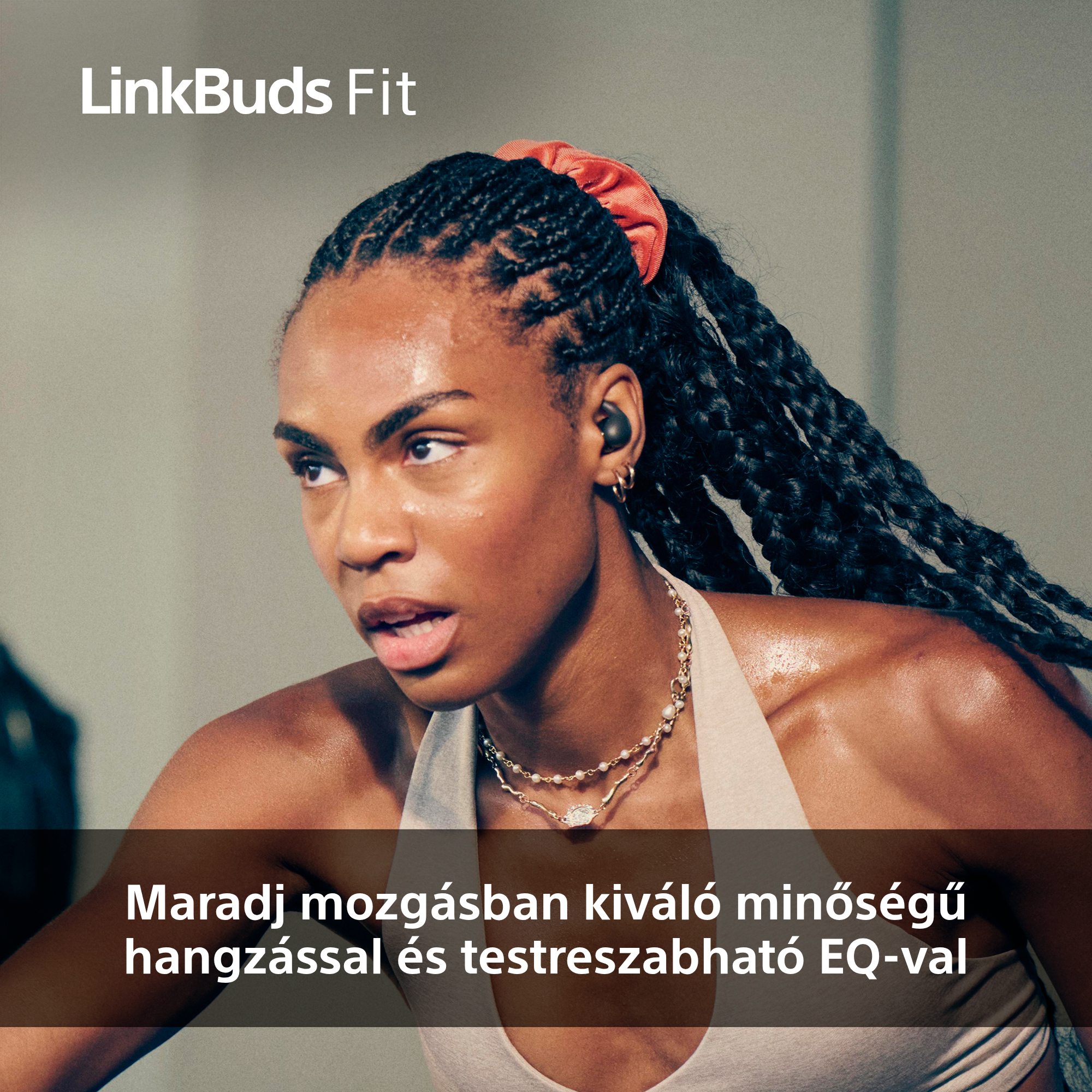 Egy fülhallgatós, izzadt nő, nyaklánccal, oldalra néz. A márkanév: LinkBuds Fit.