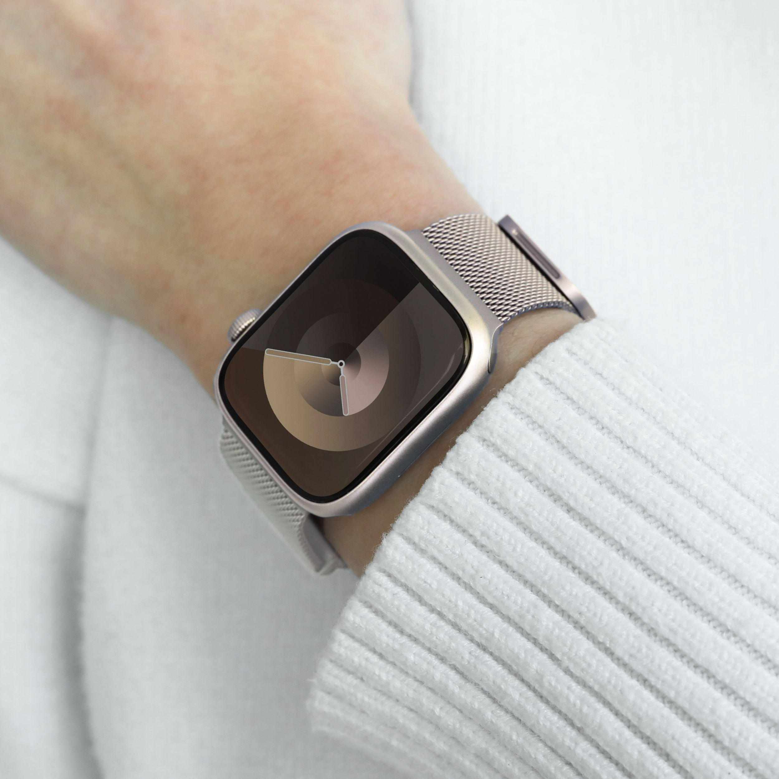 Handgelenk mit Smartwatch. Die Uhr hat ein silbernes Band und einen Bildschirm mit Kreismuster.