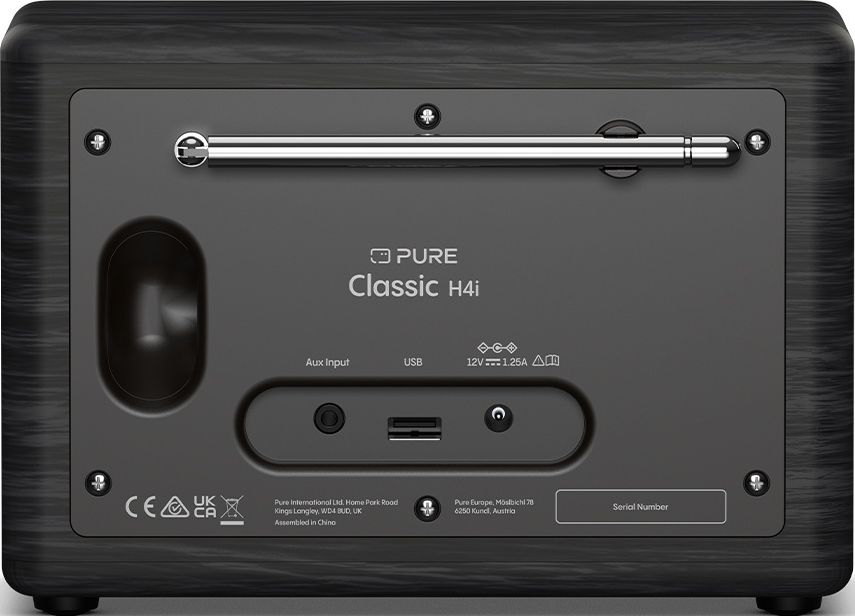 Vue arrière d'une radio Pure Classic H4i. Elle possède une antenne, divers ports et une marque. Une texture boisée sombre l'entoure.