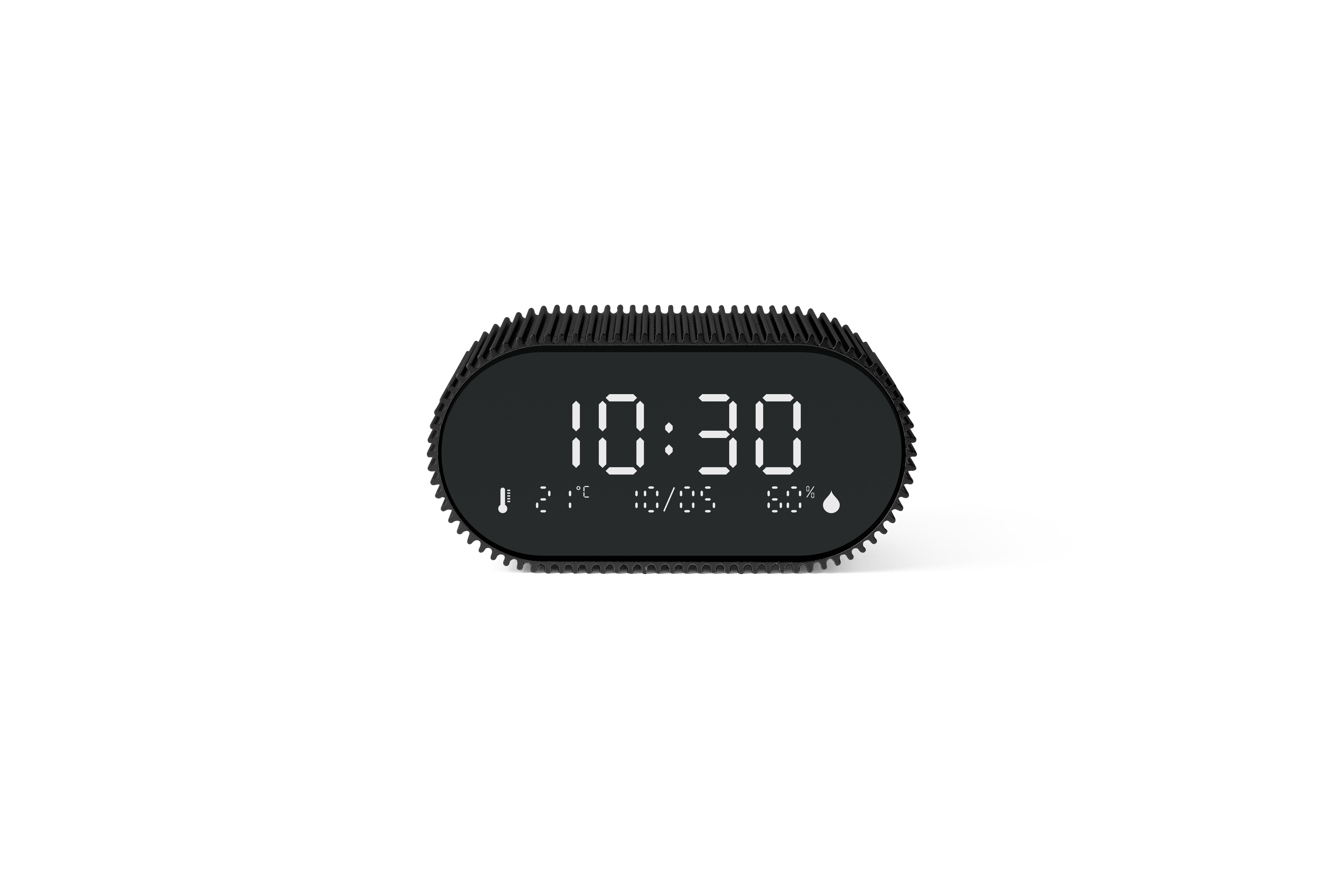 Eine schwarze Digitaluhr zeigt 10:30 an. Sie zeigt Temperatur, Datum und Luftfeuchtigkeit an. Weißer Hintergrund.