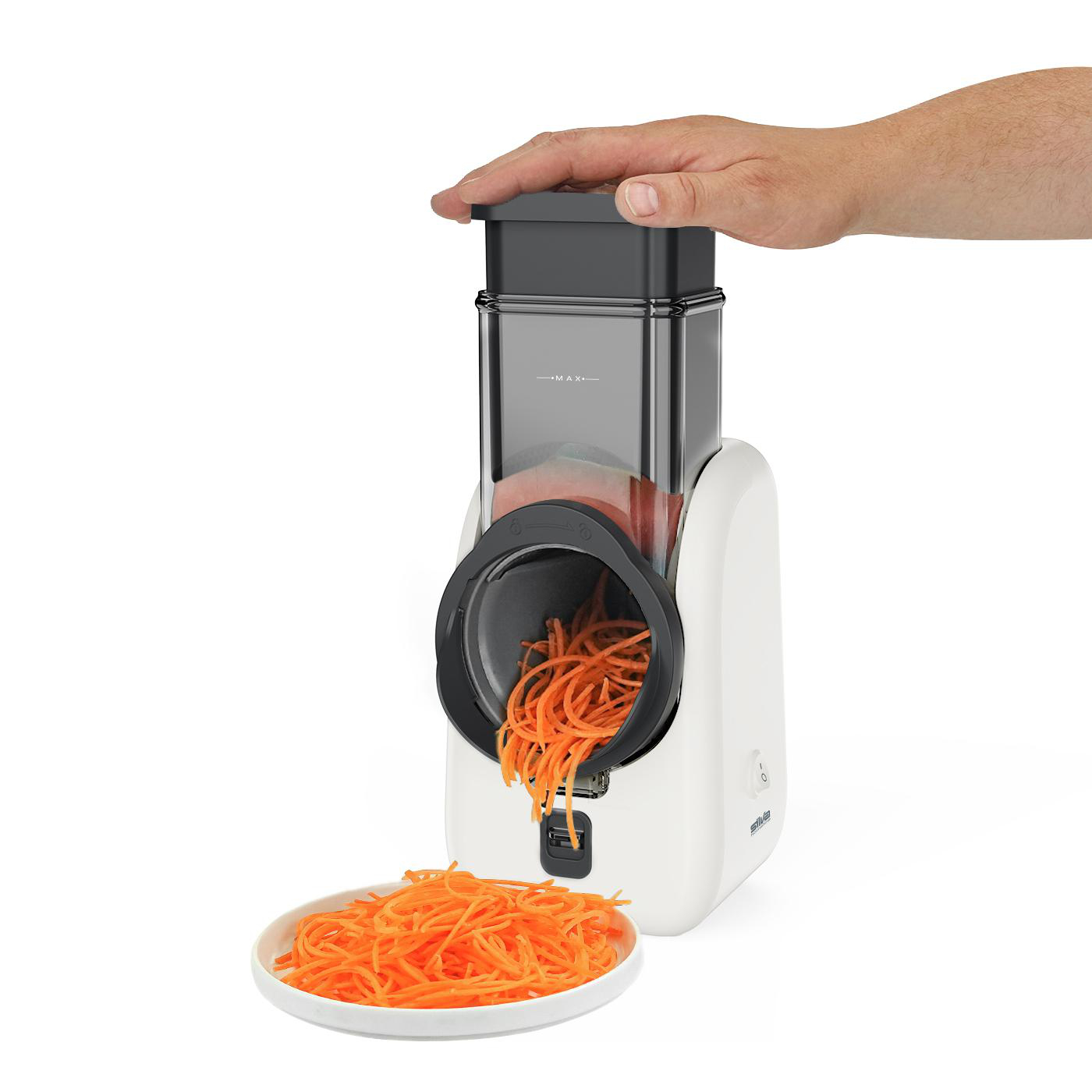 Ein weißer elektrischer Spiralschneider mit orangefarbenen Karotten-Spiralen. Eine Hand liegt obenauf. Ein Teller mit Karotten-Spiralen im Vordergrund.