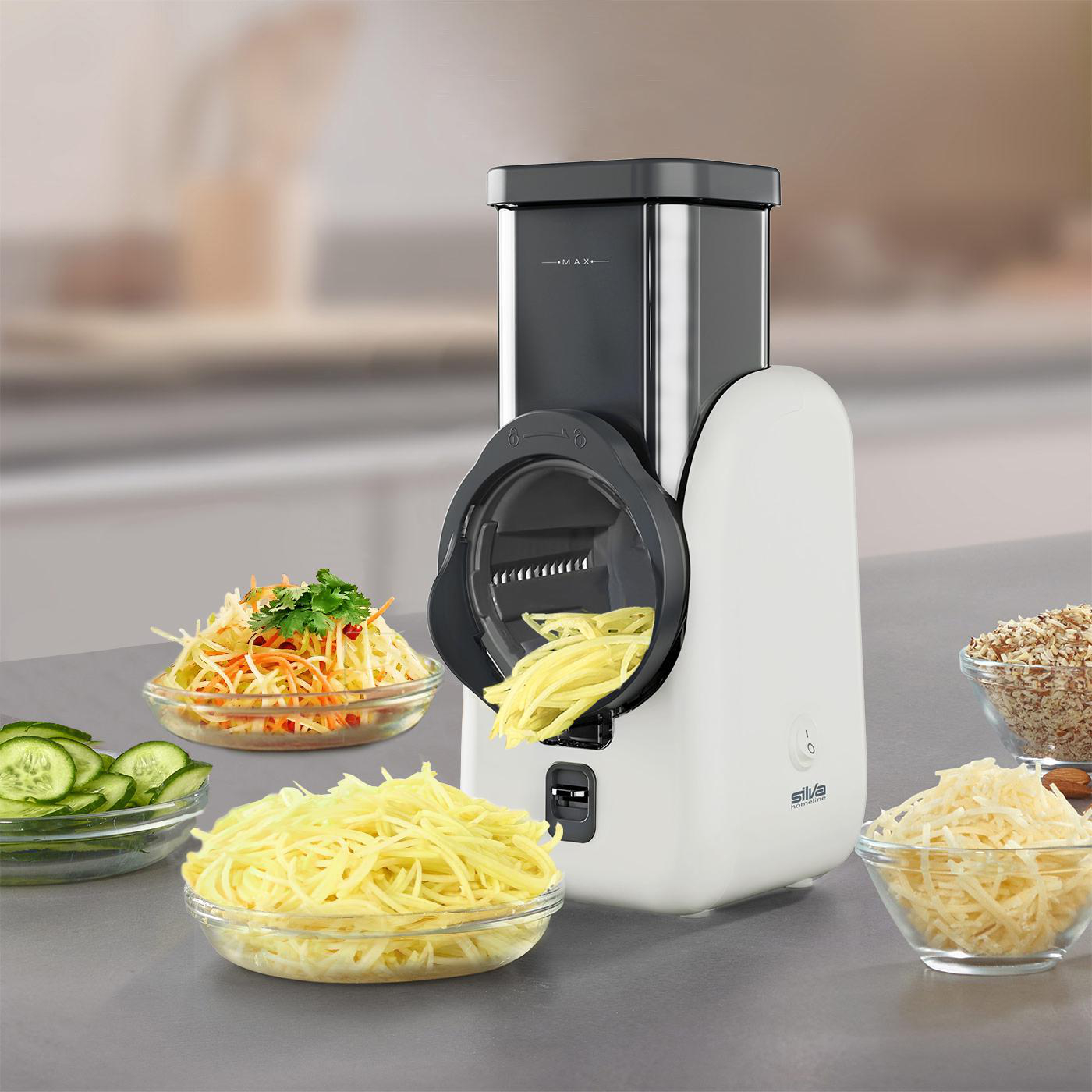 Ein weiß-schwarzer Foodprocessor zerkleinert Gemüse in Schüsseln. Zutaten wie Karotten, Gurken und Käse sind sichtbar.