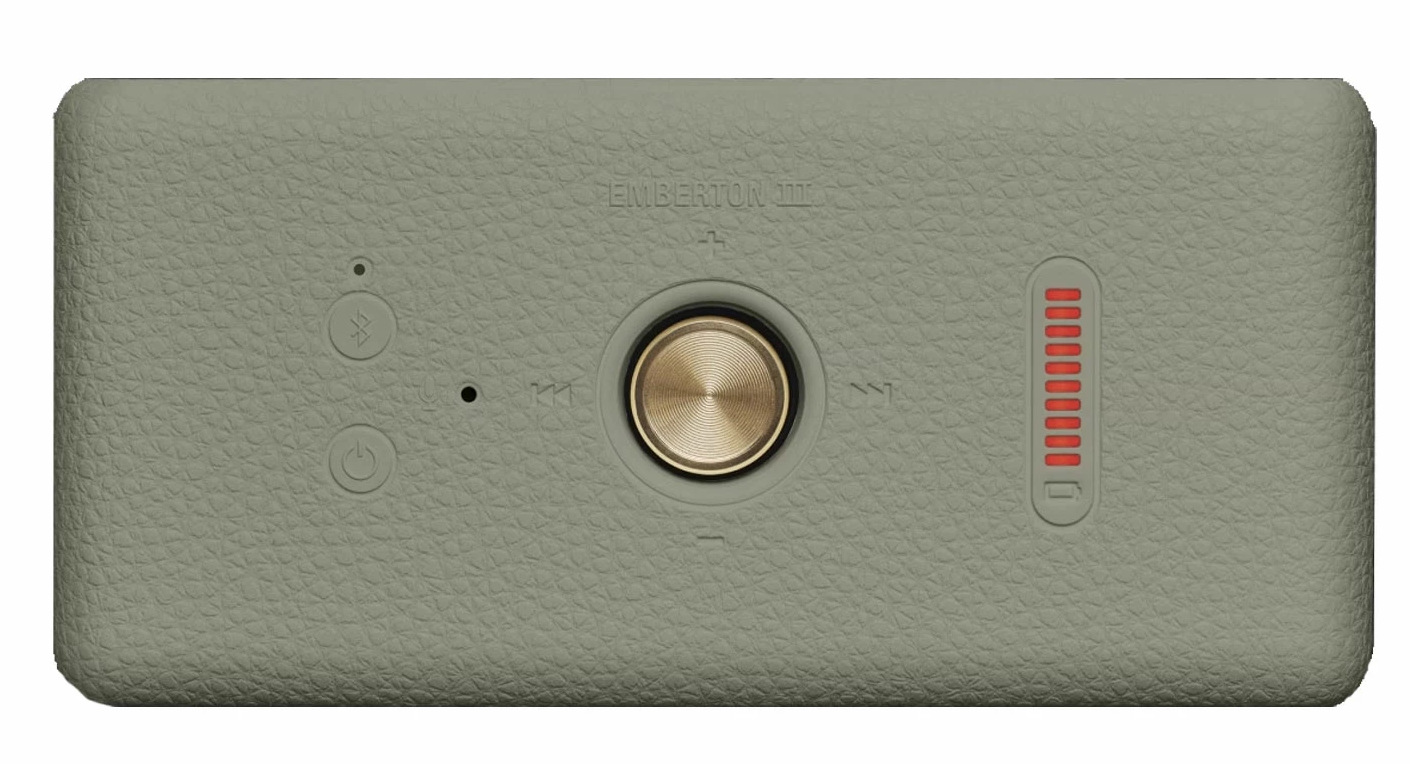 Jasnozielony prostokątny głośnik. Posiada centralne złote pokrętło, przyciski i pionowy wskaźnik baterii po prawej stronie.
