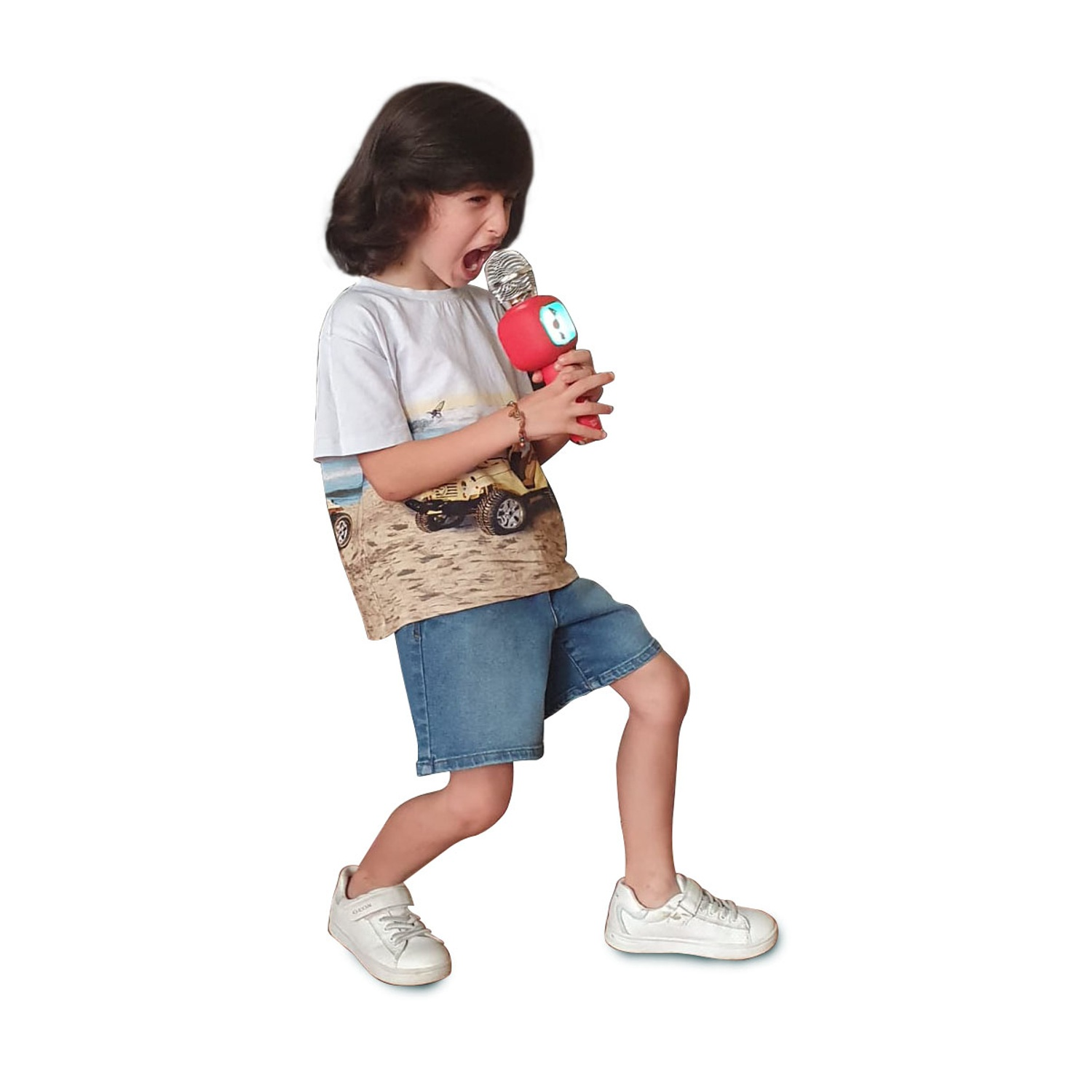 Un bambino canta in un microfono rosso, con la bocca aperta. Indossa una maglietta bianca, pantaloncini di jeans e scarpe da ginnastica bianche. Lo sfondo è bianco.