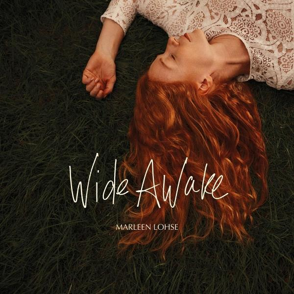 Eine Frau mit roten Haaren liegt im Gras. Sie trägt ein weißes Spitzentop. Text: 'Wide Awake' von Marleen Lohse.