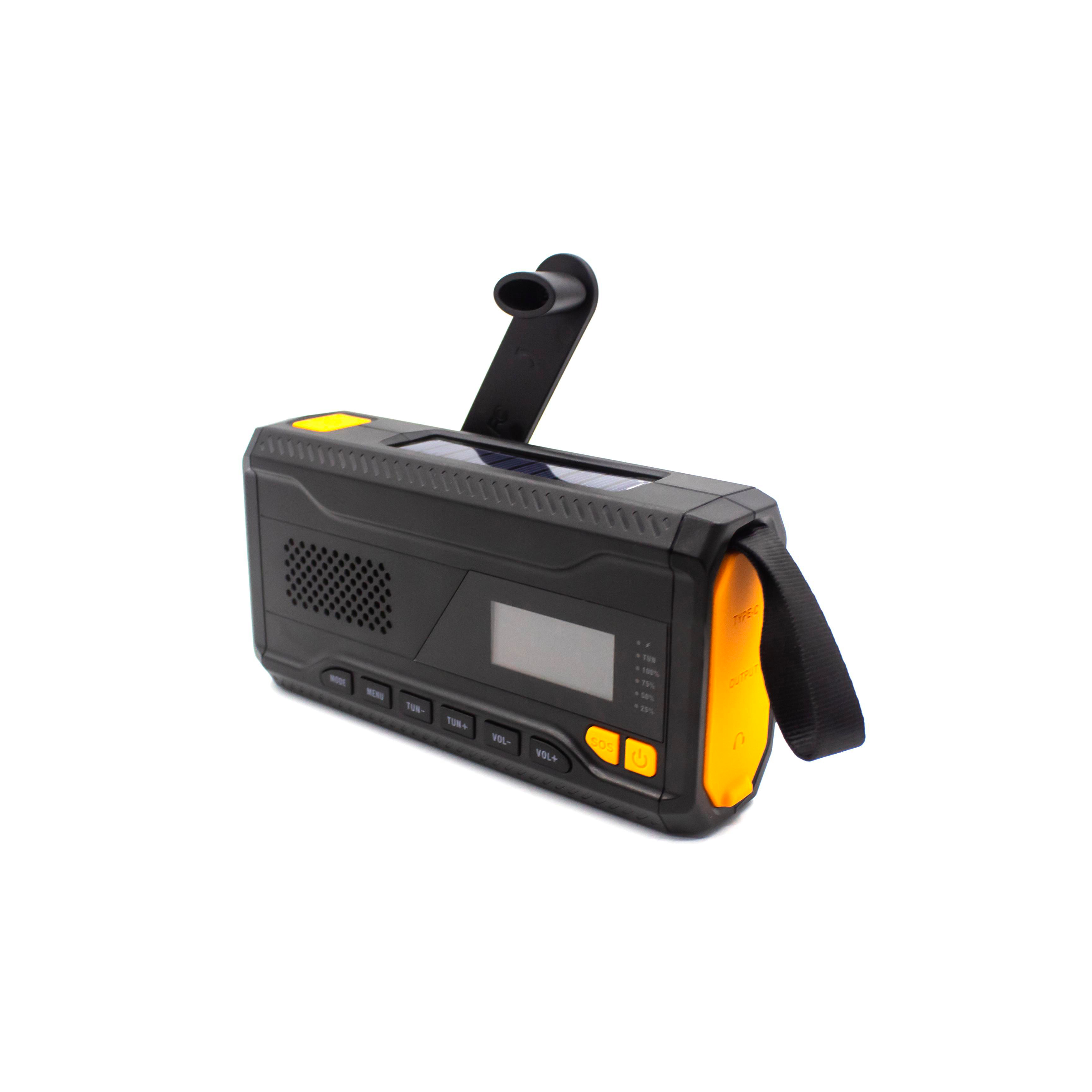 Ein schwarzes und orangefarbenes Notfallradio mit Handkurbel und Solarpanel. Es hat Knöpfe und ein Display, isoliert auf Weiß.