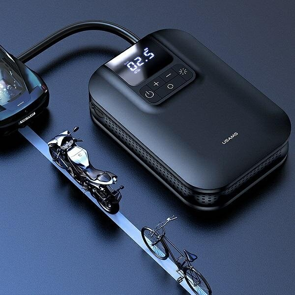 Czarny kompresor powietrza z wyświetlaczem cyfrowym i trzema miniaturowymi pojazdami: samochodem, motocyklem i rowerem na niebieskiej powierzchni.