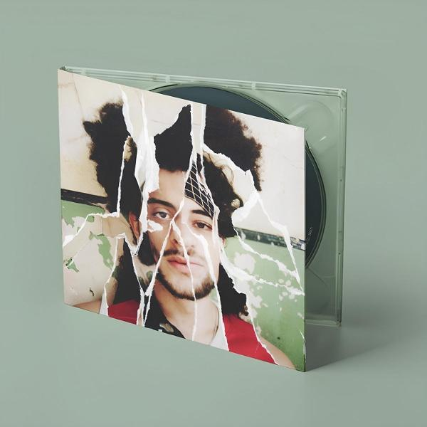 CD-Hülle mit einem zerrissenen Bild eines Mannes mit lockigem Haar und Bart. Der Hintergrund ist hellgrün.