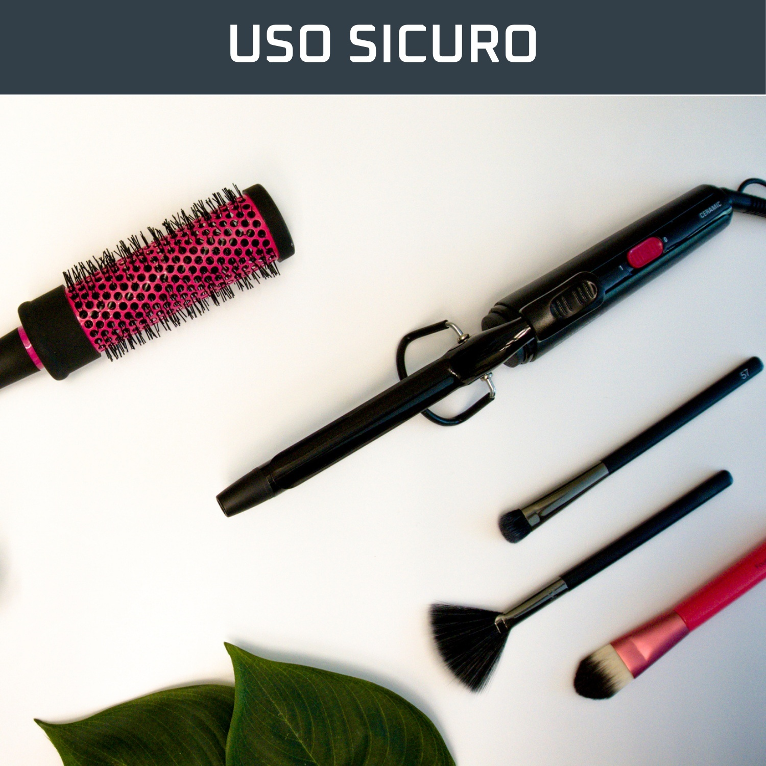 Strumenti per lo styling dei capelli e pennelli per il trucco su una superficie bianca. Include arricciacapelli, spazzola rotonda e pennelli trucco.