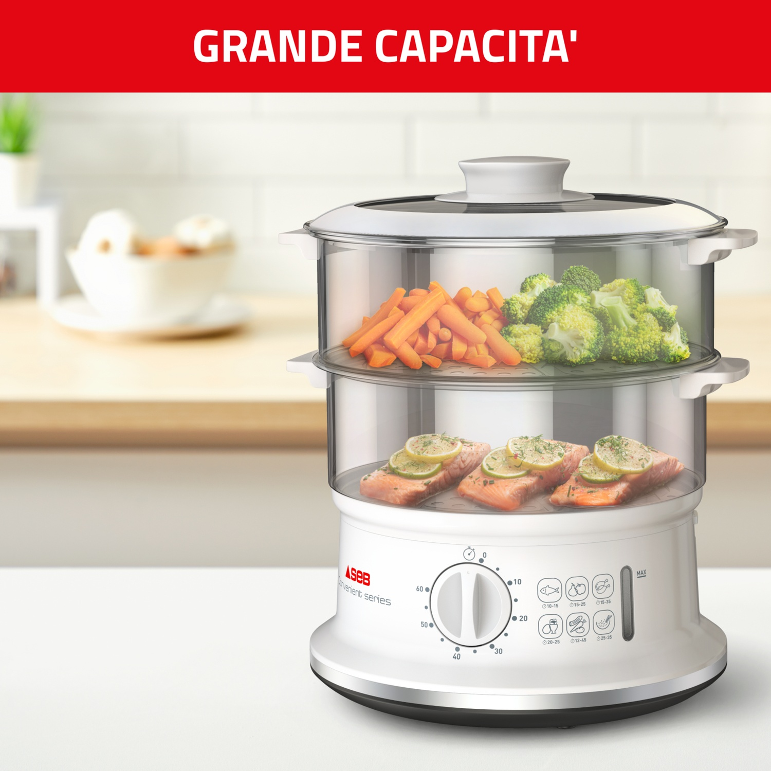 Un vaporiera bianca con scomparti in vetro. Carote, broccoli e salmone con limone sono visibili. Il testo "GRANDE CAPACITA'" è presente.