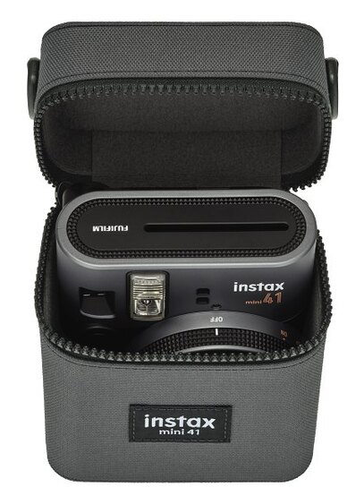 Aparat Instax Mini 41 w szarym futerale, widoczny obiektyw i lampa błyskowa.