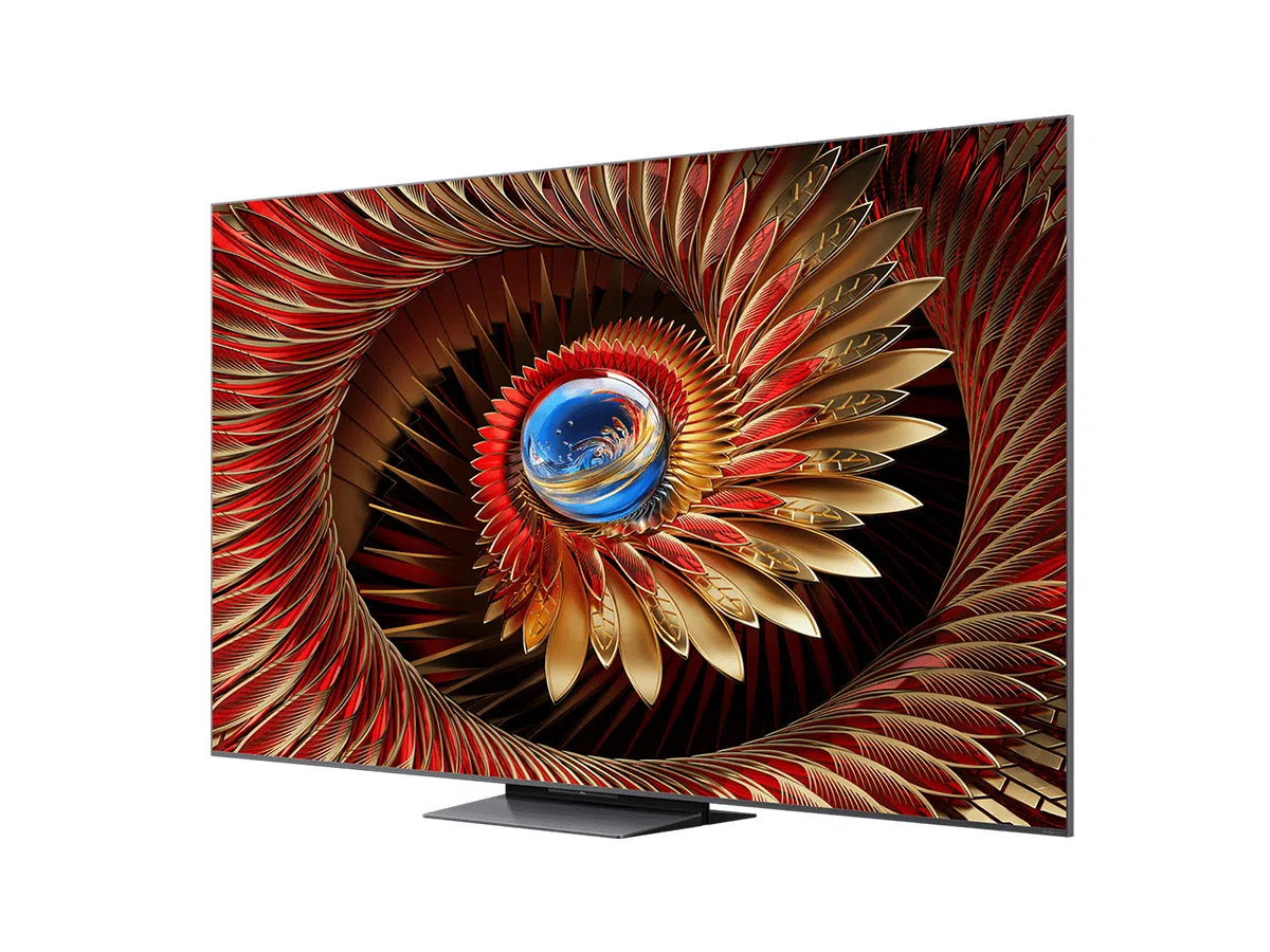 Un televisor grande muestra un diseño abstracto vibrante de plumas rojas y doradas en espiral hacia adentro, centrado en un orbe azul.