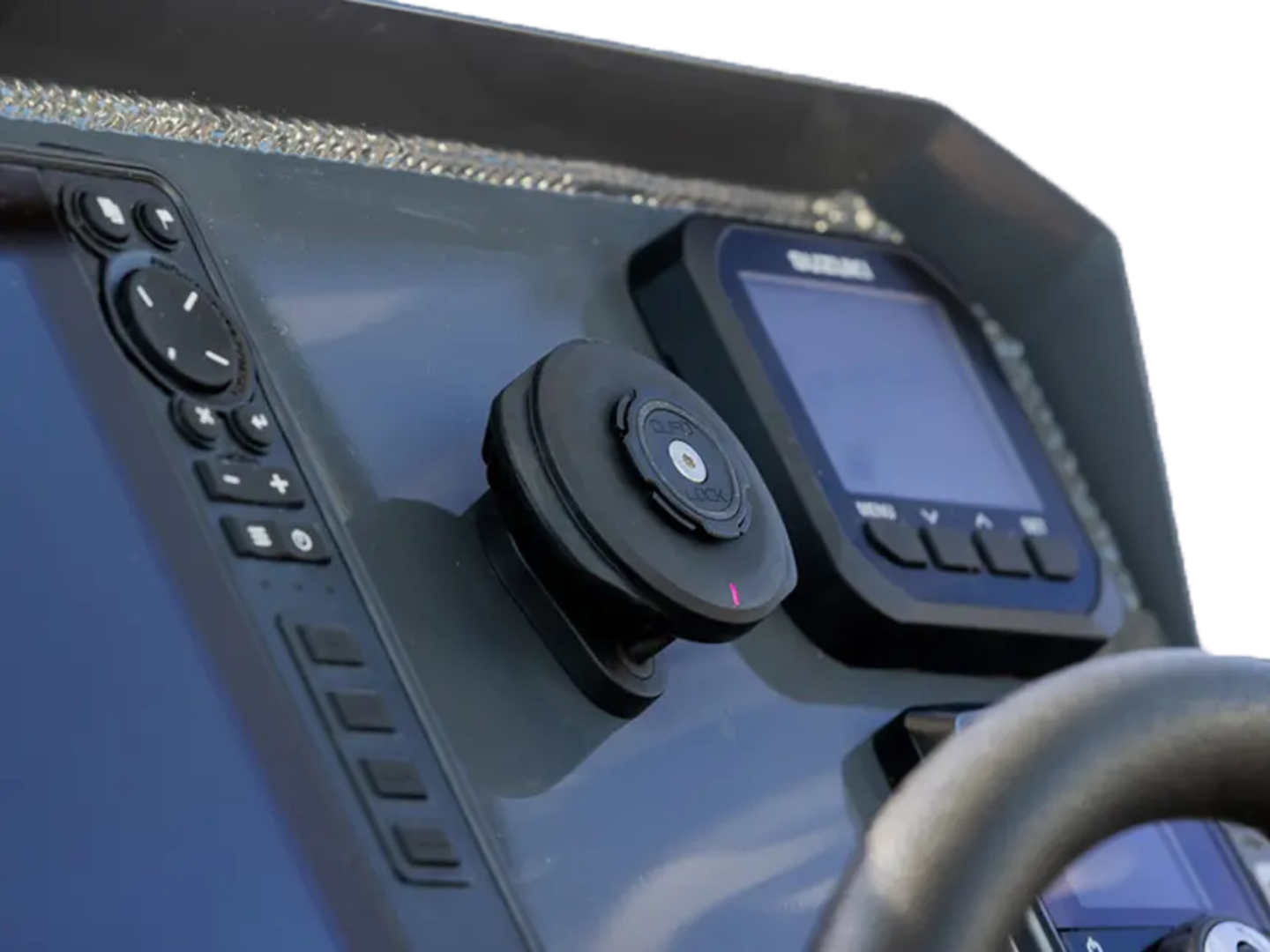 Console della barca con schermi di navigazione, pulsanti di controllo e volante. La console è grigio scuro.