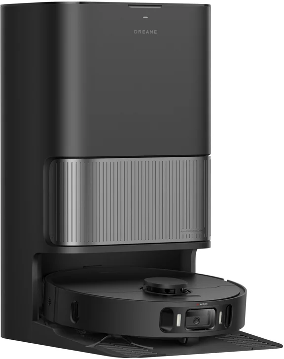 Un aspirateur robot Dreame noir est dans sa station de charge. L'aspirateur a une base ronde et une caméra.