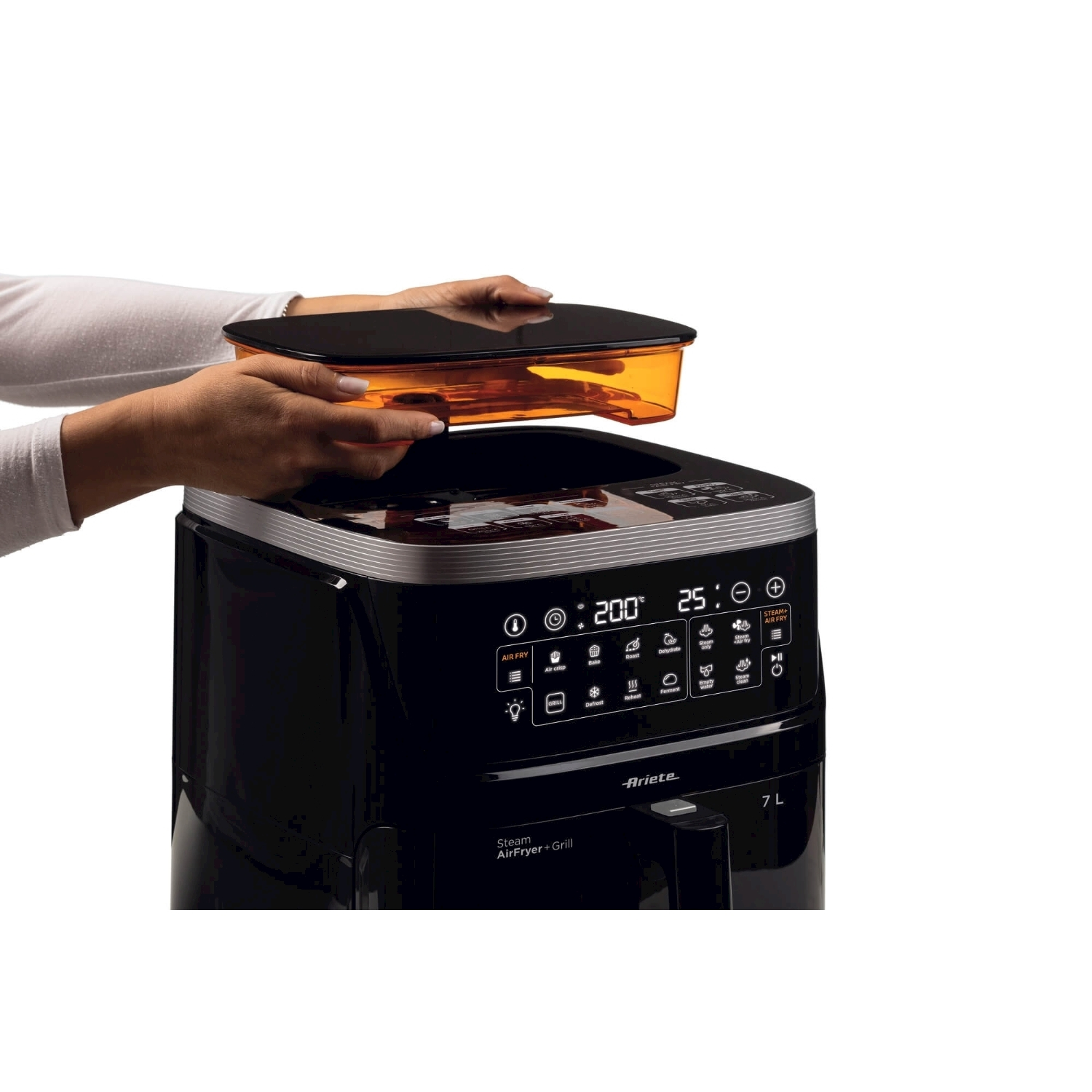 Mani che tengono un contenitore arancione sopra una friggitrice ad aria nera. La friggitrice ha un display digitale.