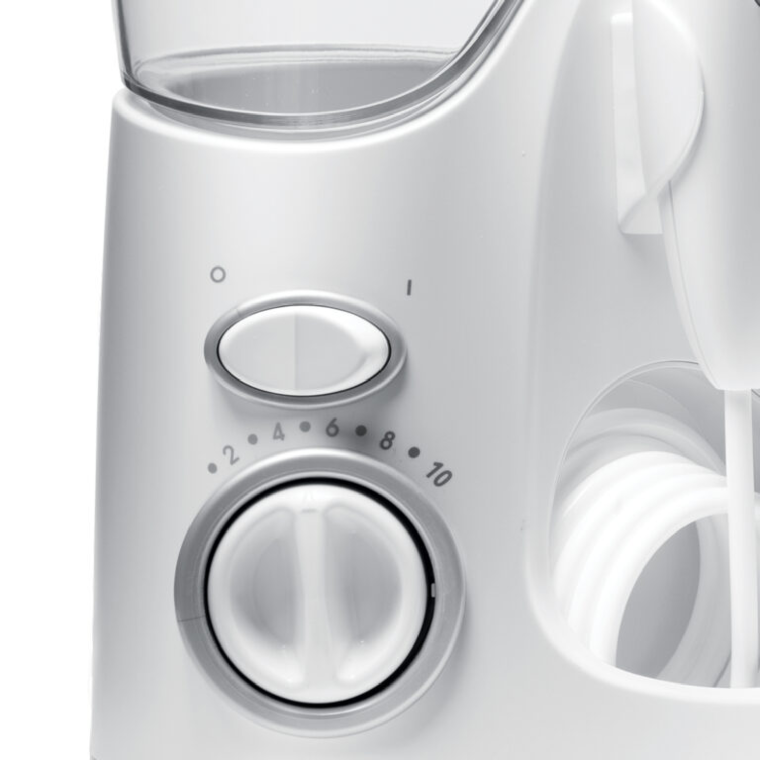 Close-up van een witte waterflosser. Het heeft een draaiknop met cijfers en een aan/uit-knop. Een witte slang is rechts opgerold.