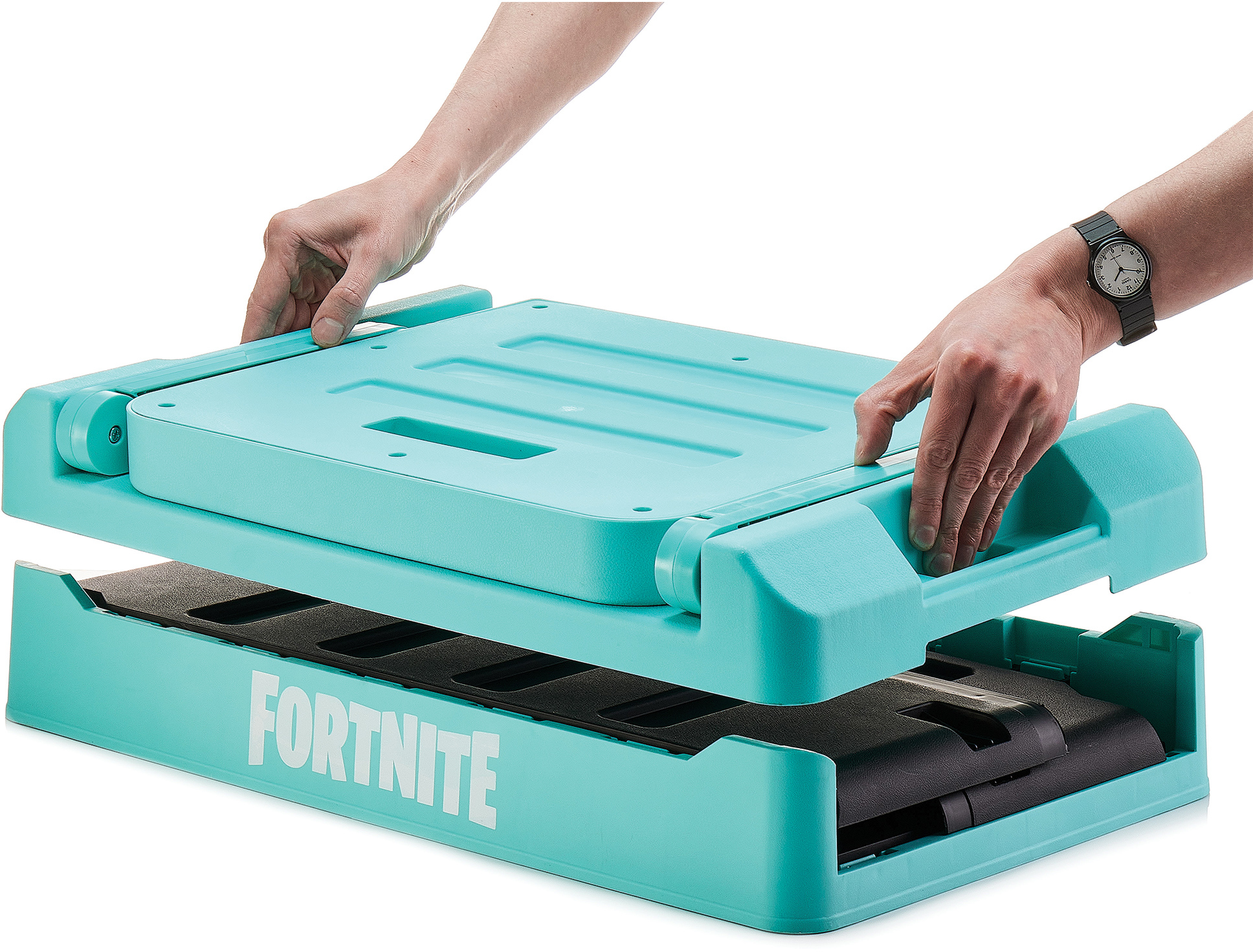 Kéz emel egy kék Fortnite tárolódobozt, fekete belsőt tárva fel. Óra a csuklón. A doboz türkiz, fehér FORTNITE felirattal.