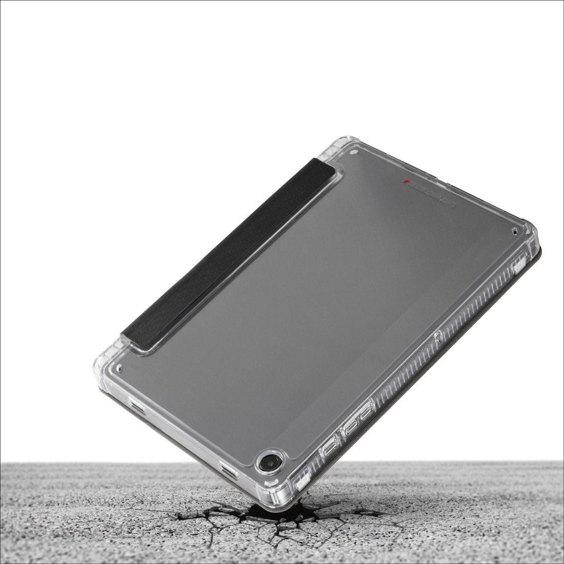 Ein Tablet in einer transparenten Schutzhülle fällt auf eine gerissene Betonoberfläche. Die Hülle hat eine schwarze Abdeckung, der Bildschirm ist sichtbar.