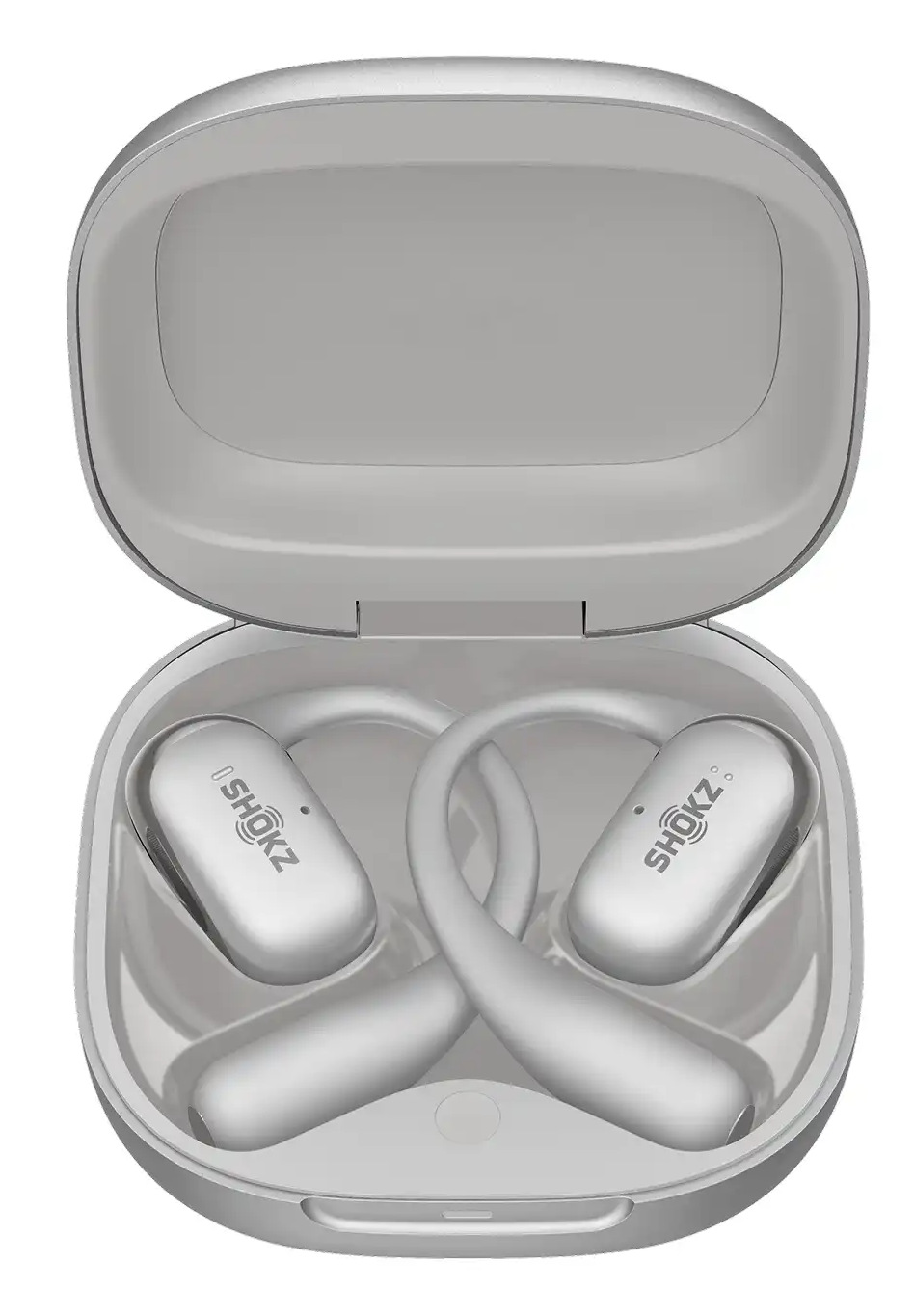 Otwarta szara obudowa z dwoma srebrnymi słuchawkami Shokz. Obudowa jest prostokątna z zakrzywioną pokrywą. Słuchawki są zakrzywione.