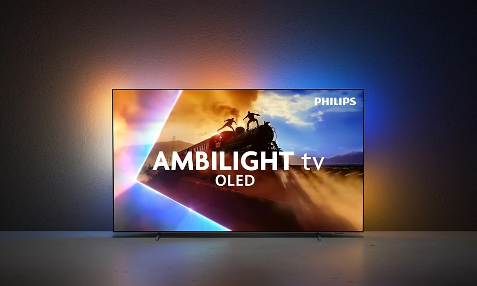 Telewizor OLED Philips Ambilight. Ekran pokazuje scenę z pociągiem i dwiema postaciami. Telewizor ma kolorowe podświetlenie.