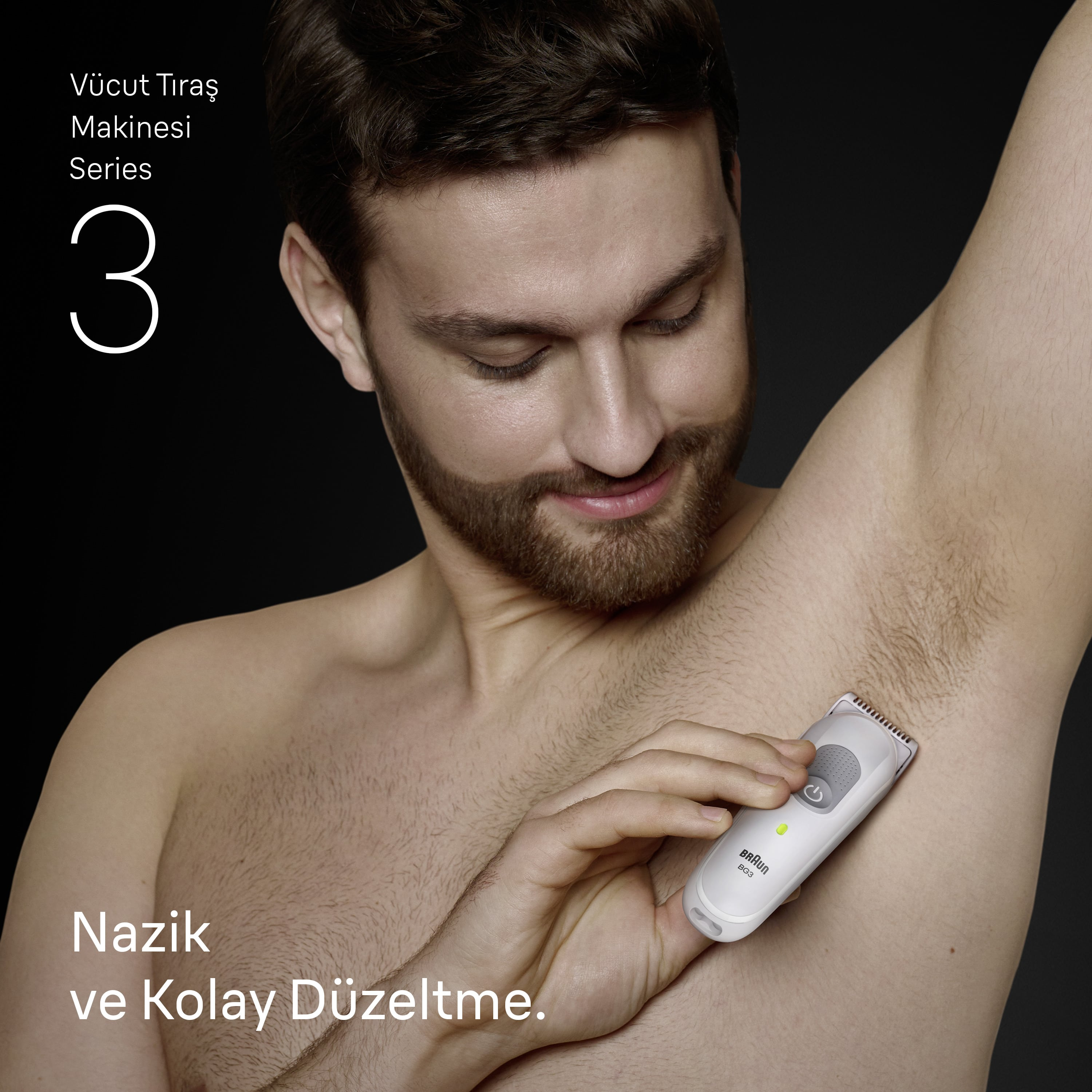 Bir adam beyaz bir düzeltici ile koltuk altını tıraş ediyor, gülümsüyor. Arka plan karanlık.
