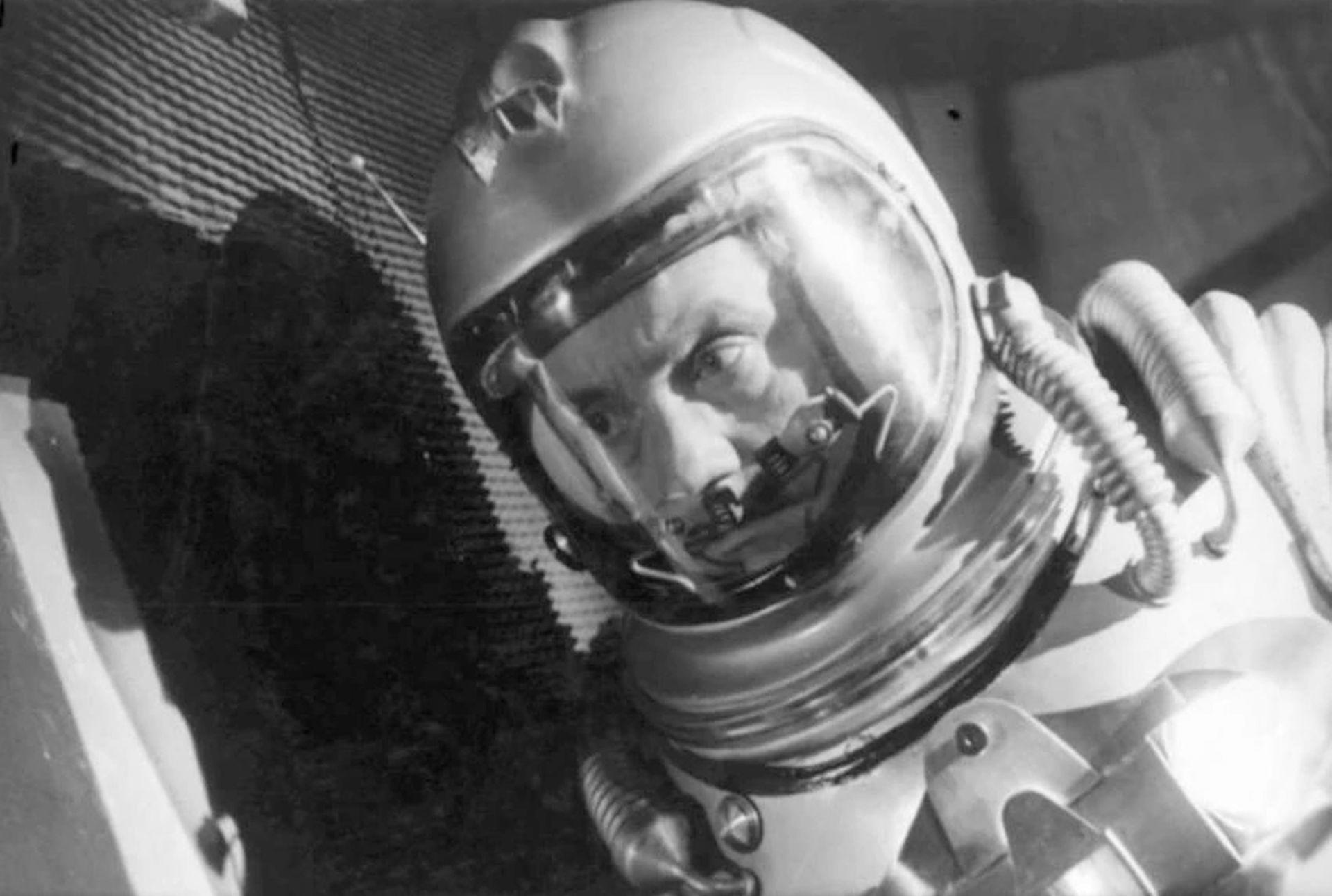 Schwarz-Weiß-Foto zeigt einen Astronauten mit Helm. Der Astronaut schaut in die Kamera. Der Hintergrund ist dunkel.