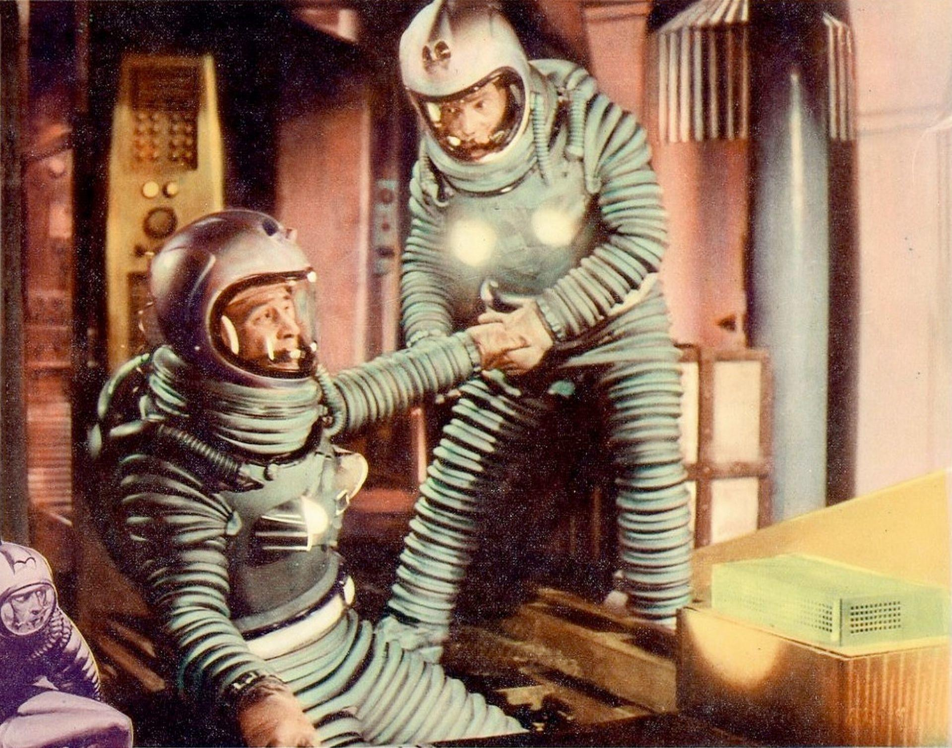Zwei Astronauten in gestreiften Anzügen und Helmen geben sich die Hand. Im Hintergrund befinden sich ein Bedienfeld und eine Kiste. Retro-Sci-Fi.