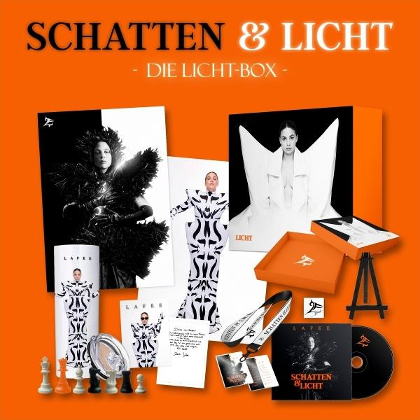 Ein orangefarbenes Box-Set mit dem Text "SCHATTEN & LICHT". Es enthält Fotos, eine CD und andere Artikel mit einer Frau.