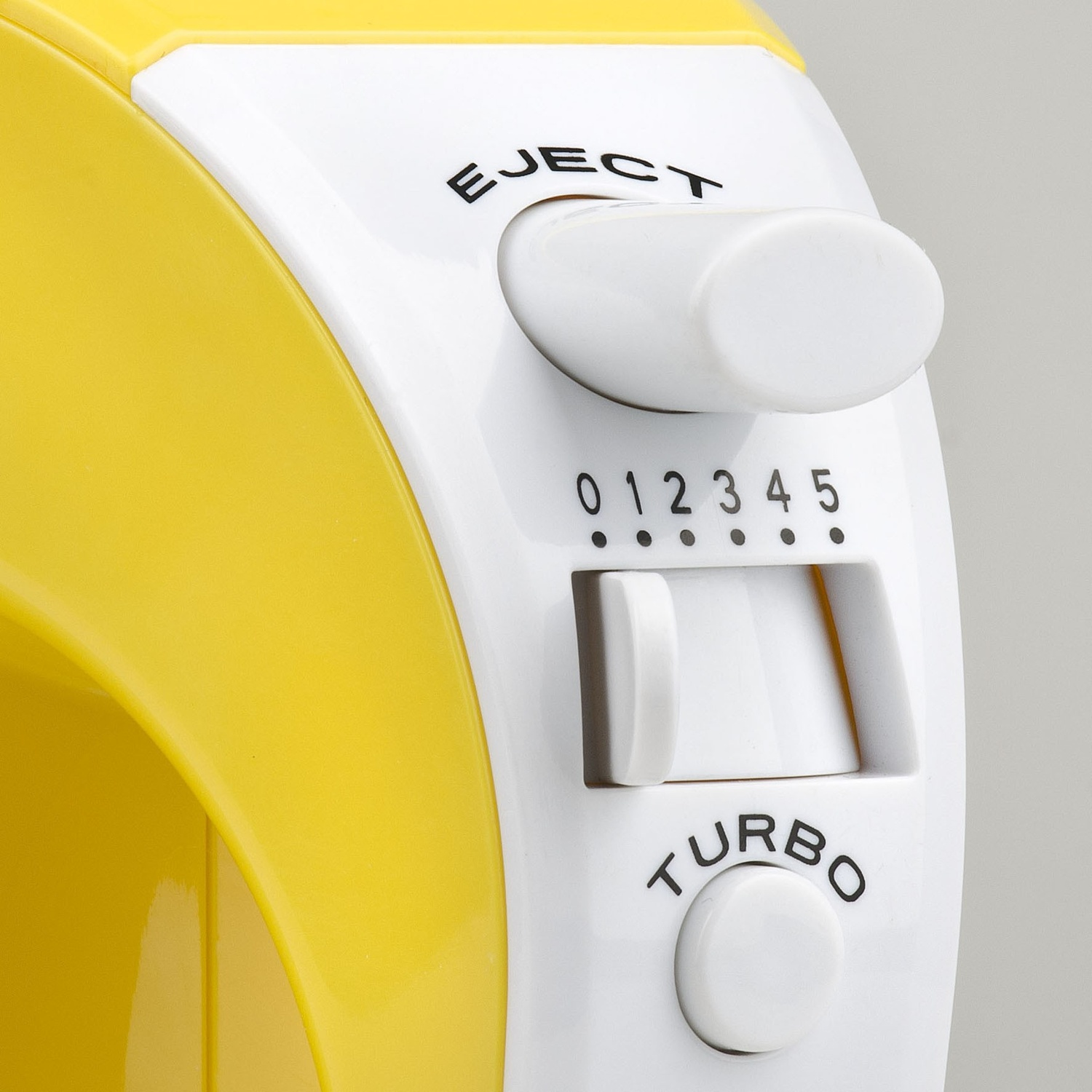 Primo piano di un frullatore a mano giallo e bianco. Include un pulsante di espulsione, un quadrante di velocità (0-5) e un pulsante turbo.