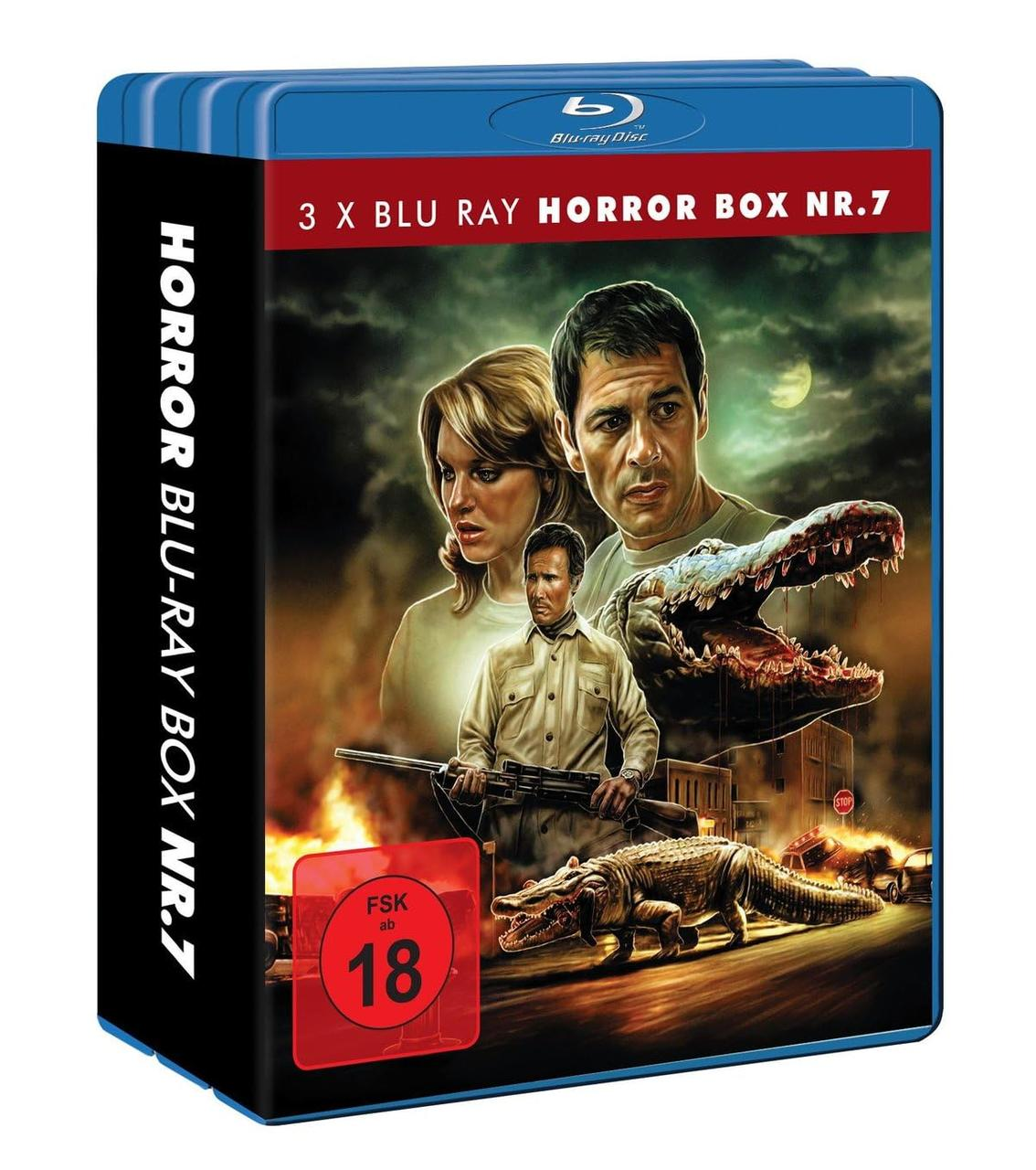 Blu-ray-Box-Art mit Horrorthema. Zeigt einen Mann mit einer Waffe, zwei Personen und Krokodile. Flammen und eine Stadt im Hintergrund.