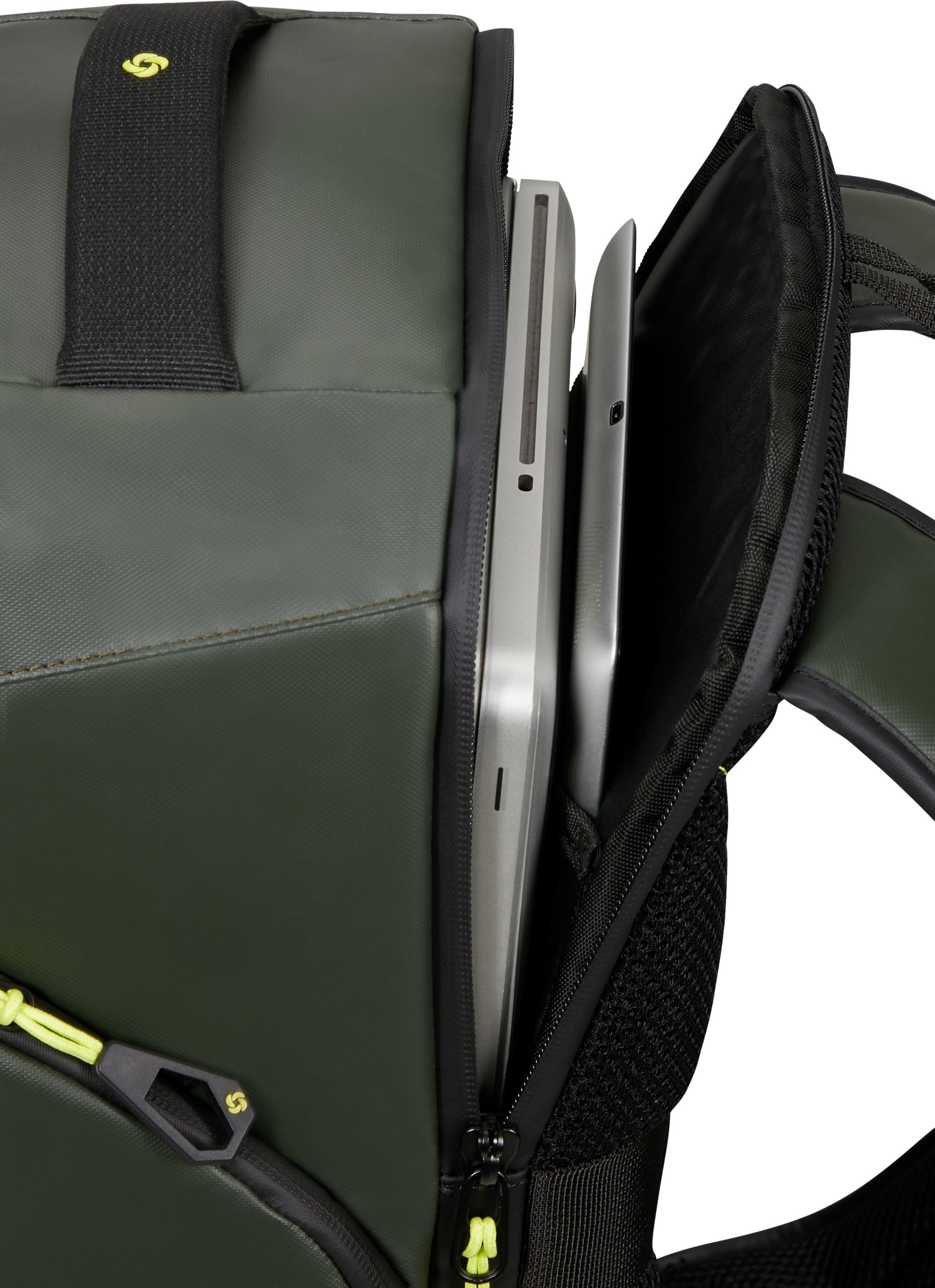 Zöld hátizsák közelképe laptop-pal és tablettel. Fekete pántok és sárga cipzár látható.