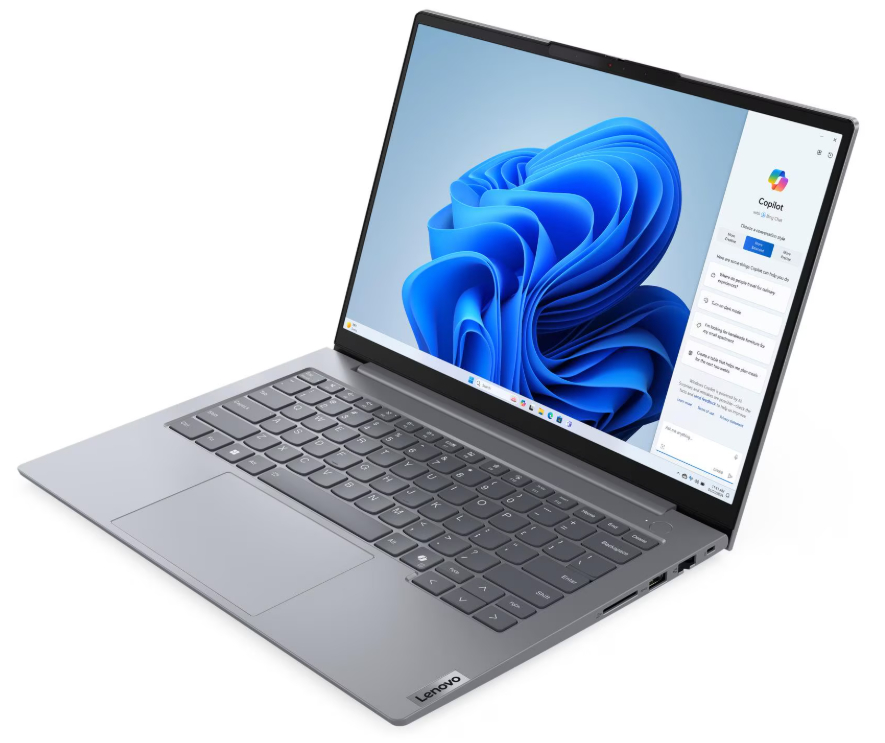 Ein silbernes Lenovo-Laptop ist geöffnet und zeigt einen blauen Windows 11-Hintergrund mit einer Copilot-Seitenleiste.