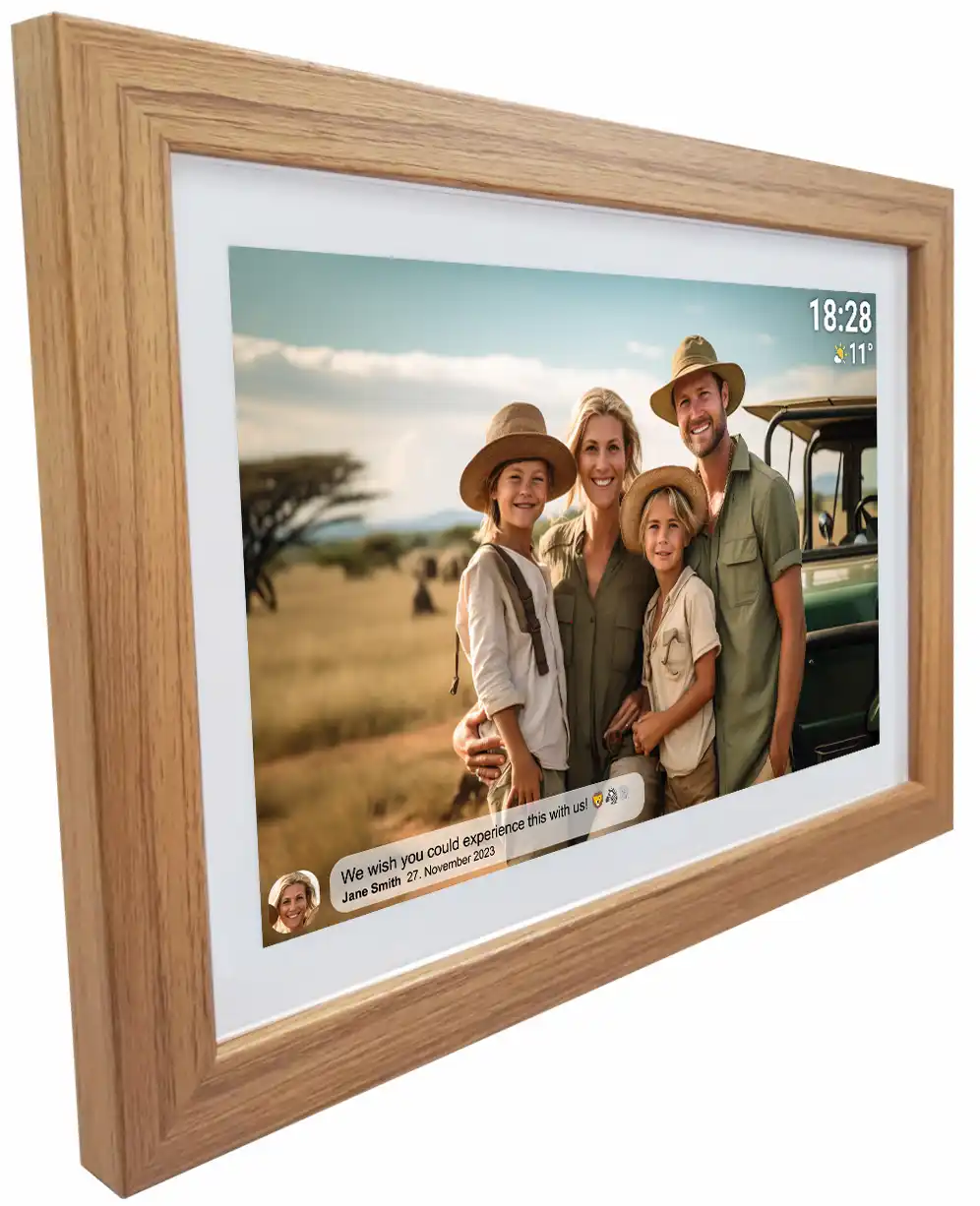 Cadre photo numérique affichant photo de famille en safari. Cadre en bois. Famille porte des chapeaux. Heure : 18:28. Texte: Nous souhaitons...