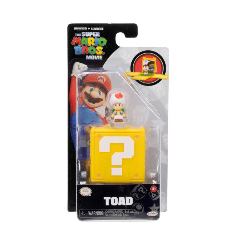 Ein Toad-Spielzeug in einer Verpackung. Die Verpackung hat Mario und das Super Mario Bros. Movie-Logo. Vorne ist ein gelber Fragezeichen-Block.