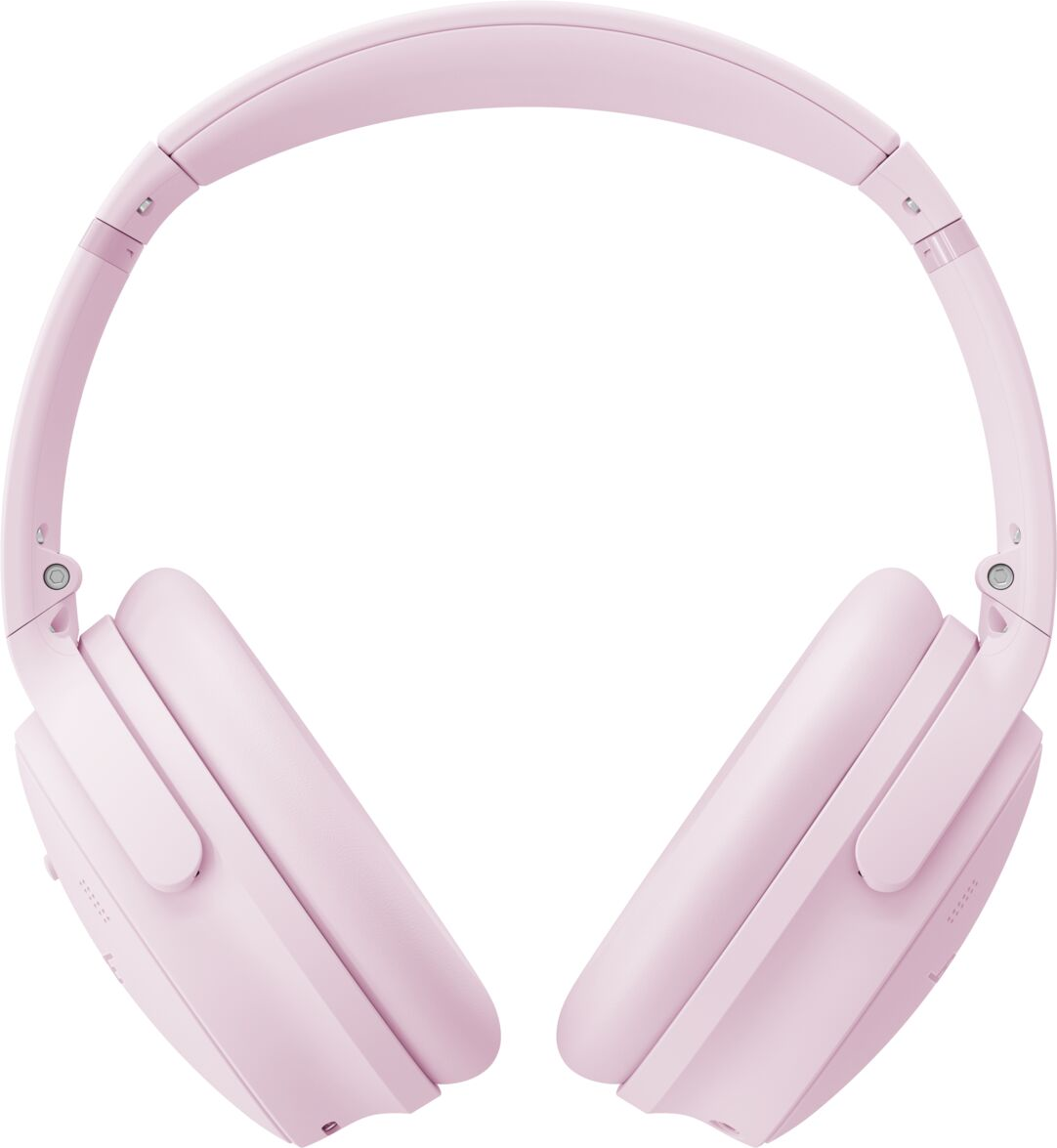 Une paire d'écouteurs rose clair, sur fond blanc. Le casque a un bandeau et des oreillettes rembourrés.