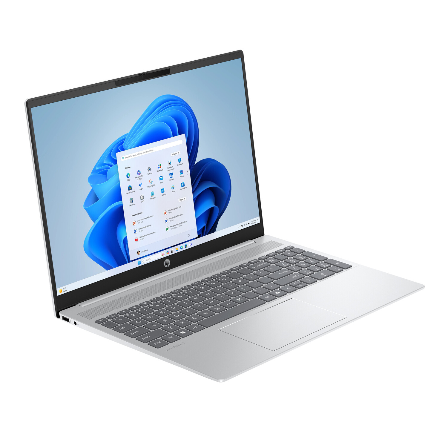 Silver HP laptop on a white surface with the Windows 11 interface on the screen. Keyboard and touchpad are visible.