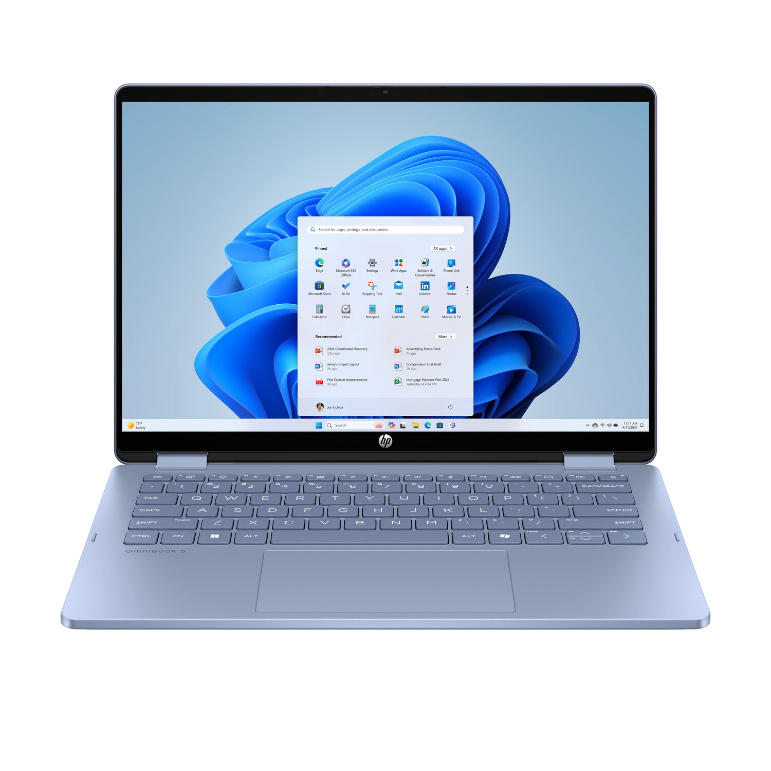A light blue HP OmniBook 5 laptop displays the Windows 11 home screen. The screen shows app icons and a search bar. Keyboard visible.