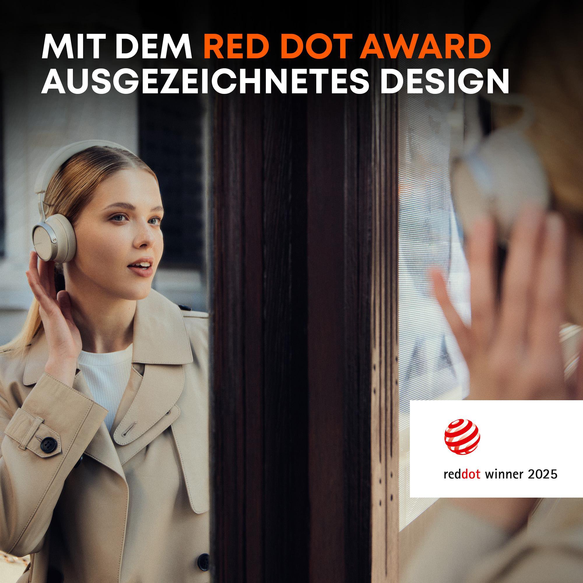 Frau mit Kopfhörern, beigem Mantel, berührt ihren Kopf, in der Nähe eines Fensters, Red Dot Logo in der Ecke.