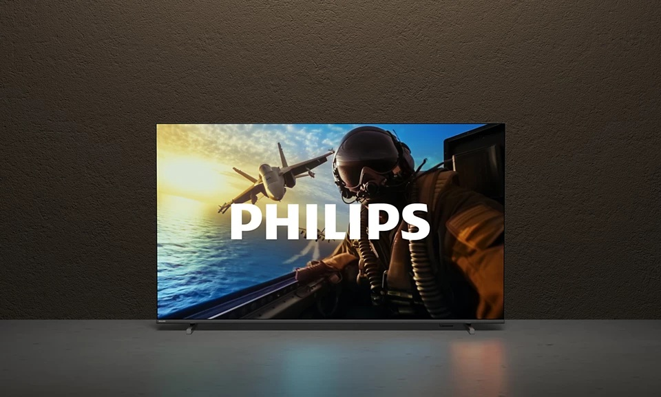 Telewizor Philips wyświetla scenę z myśliwcem. Pilot w kokpicie, z myśliwcem na niebie i logo Philips.