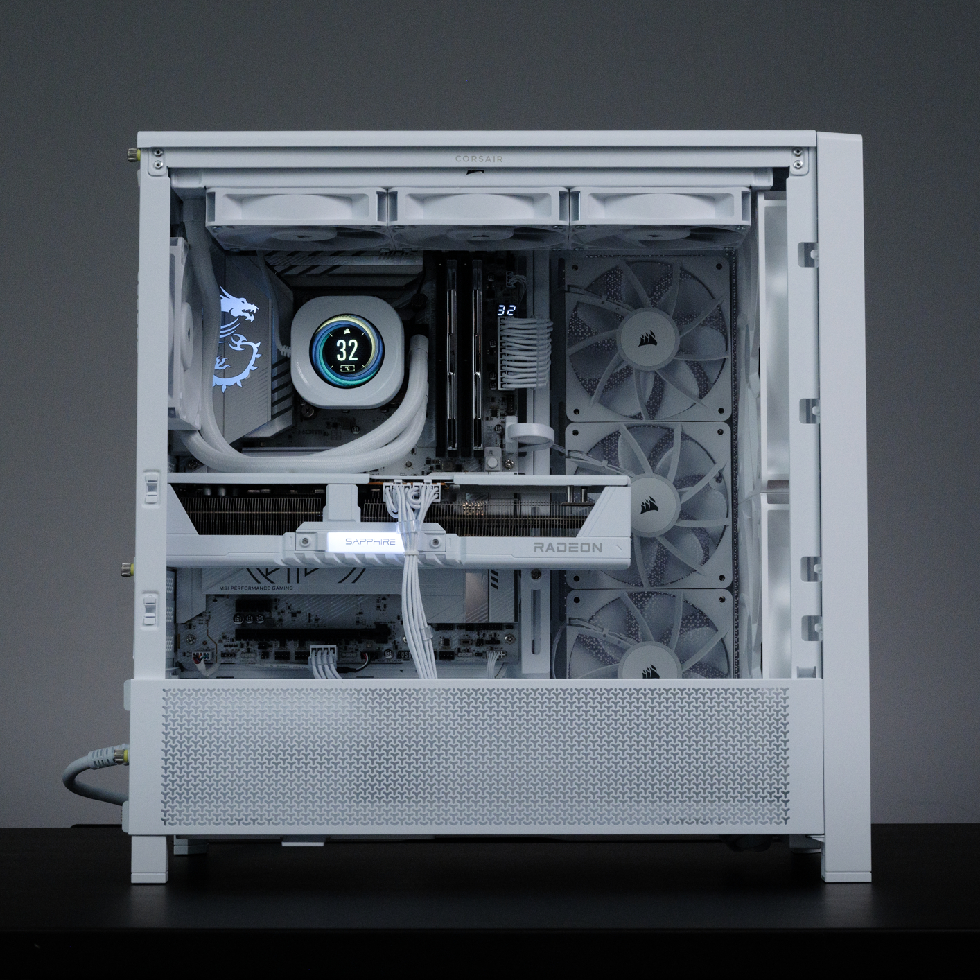 Weißes PC-Gehäuse mit sichtbaren internen Komponenten. Enthält Lüfter, einen Wasserkühler und eine Grafikkarte. Das Gehäuse steht auf schwarzem Untergrund.