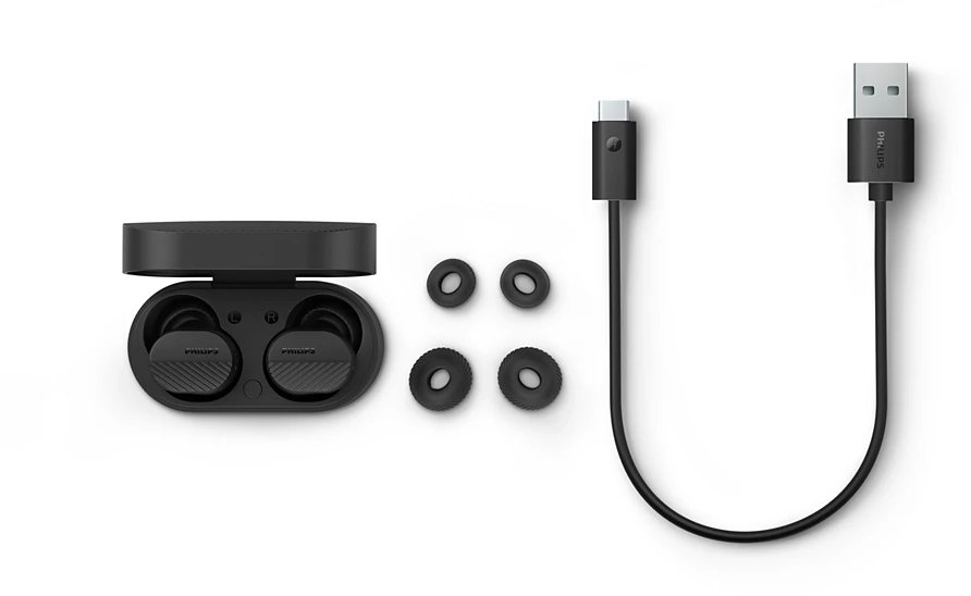 Fekete vezeték nélküli fülhallgató, töltőtok, extra füldugók, USB-C és USB-A töltőkábel fehér háttérrel.