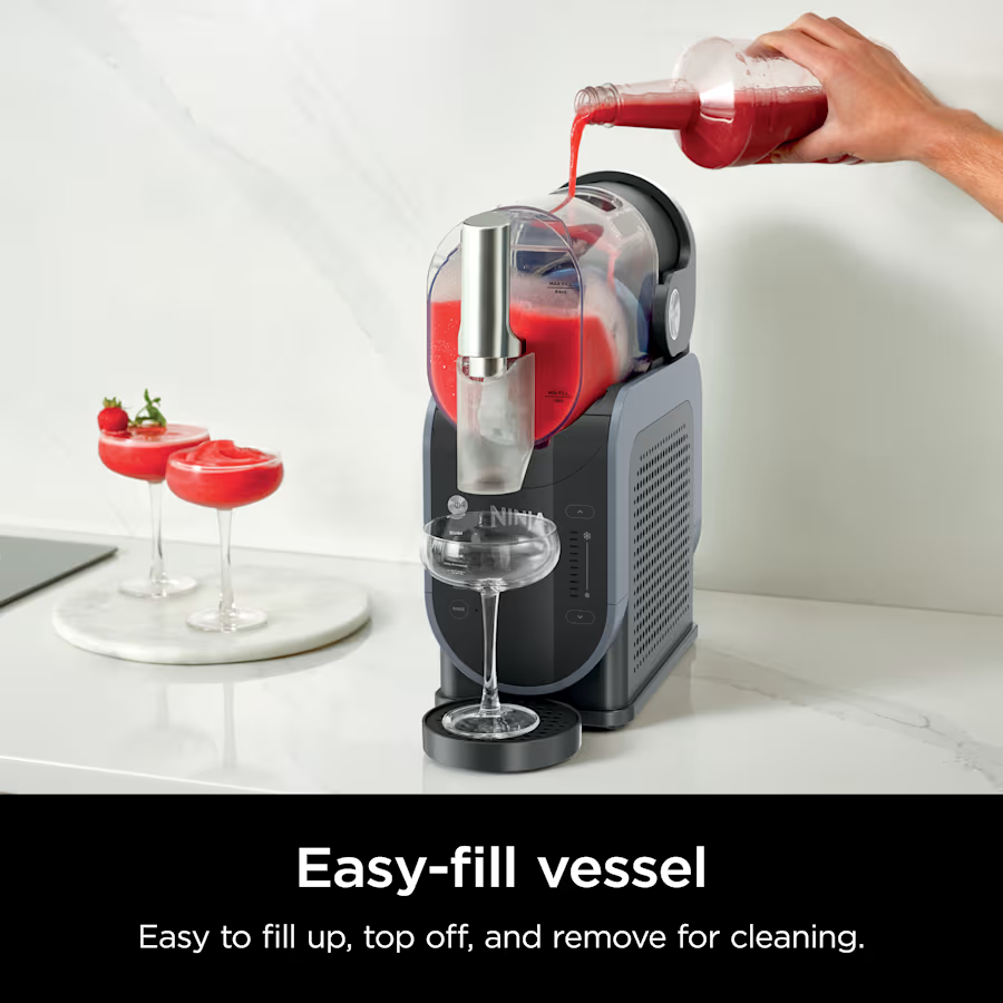 Eine Person gießt rote Flüssigkeit in einen Mixer. Links sind zwei Cocktails mit Erdbeeren. Ein Glas steht vor dem Mixer.