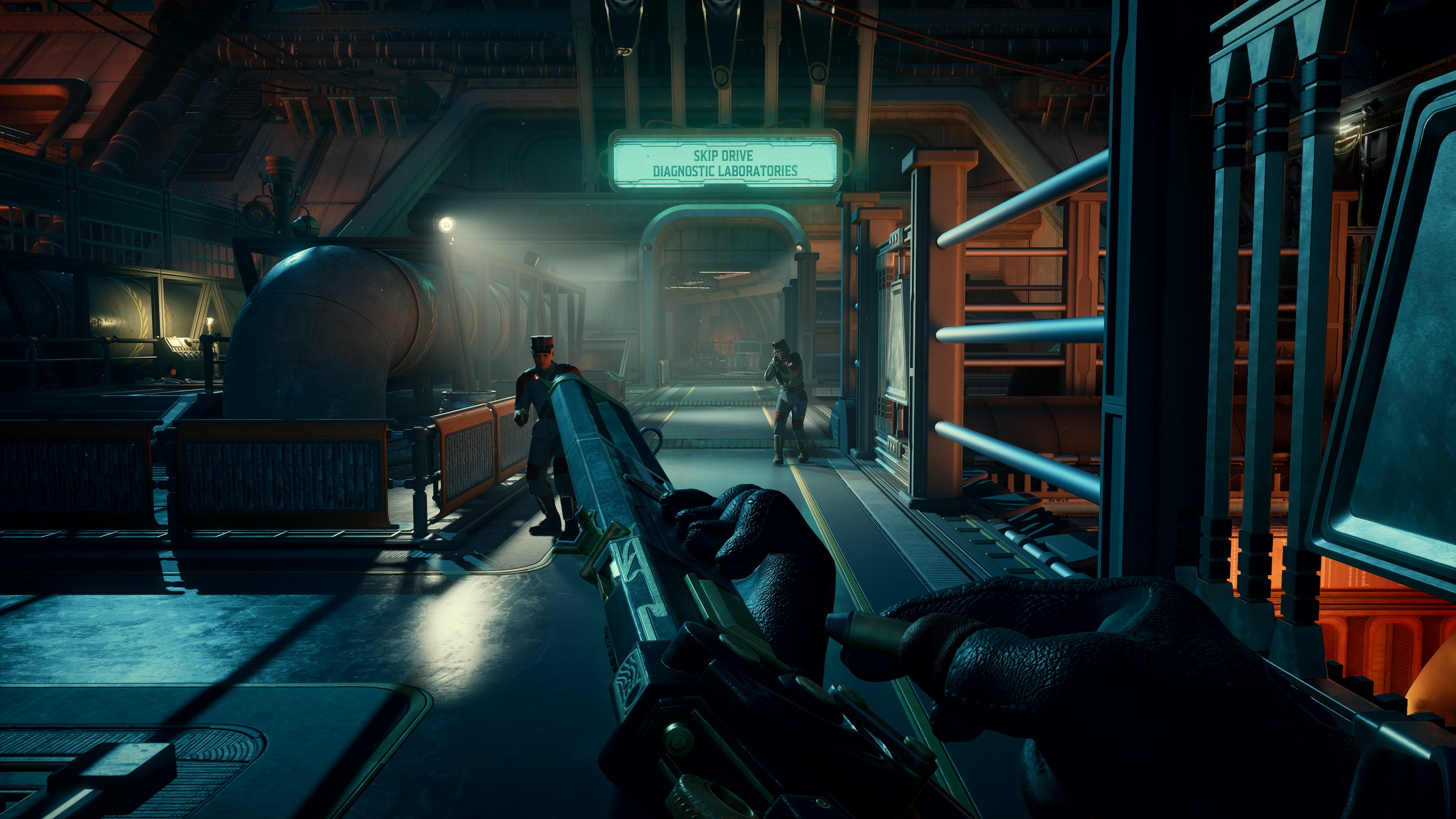 Vue subjective d'un couloir futuriste. Une arme est tenue. Deux personnages sont en arrière-plan. Panneau: 'Skip Drive Diagnostic Laboratories'.