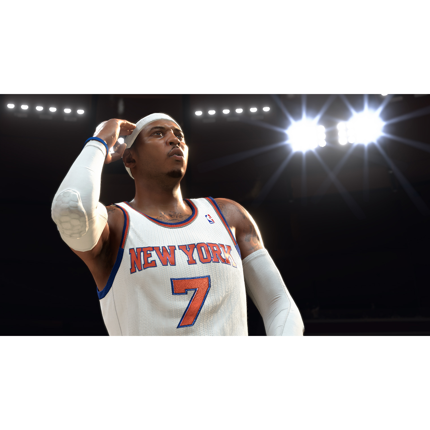 Basketball player in white jersey with 'NEW YORK' and number 7. He's touching his head, bright lights in the background.