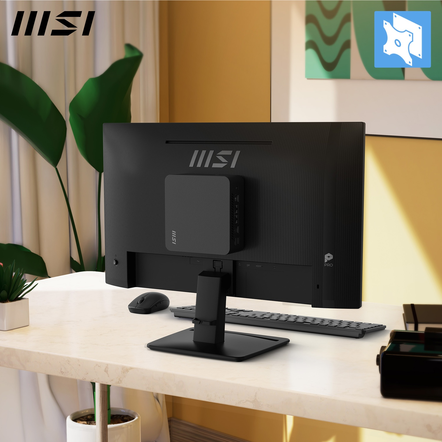 Een zwarte computermonitor met een kleine zwarte computer eraan, op een witte tafel met muis en toetsenbord. Op de achtergrond een plant.