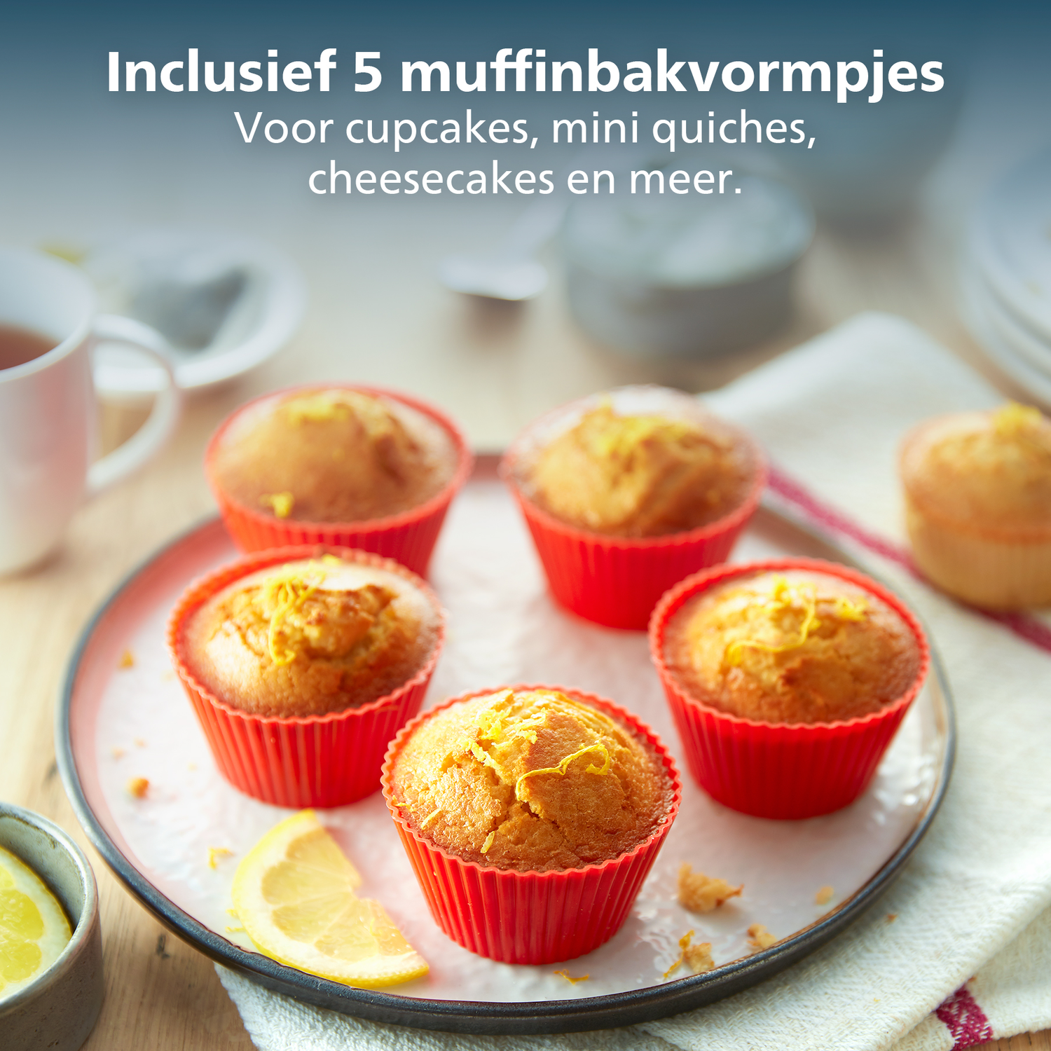 Des muffins dans des tasses rouges sur une assiette avec une tranche de citron. Le texte ci-dessus indique 'Comprend 5 moules à muffins'.