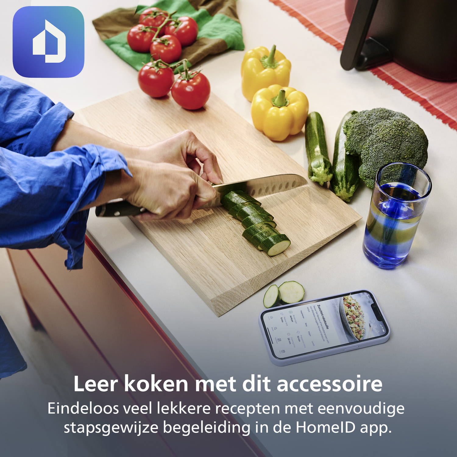 A person slices zucchini on a wooden board. Tomatoes, yellow peppers, zucchini, and broccoli are nearby. A phone displays a recipe.