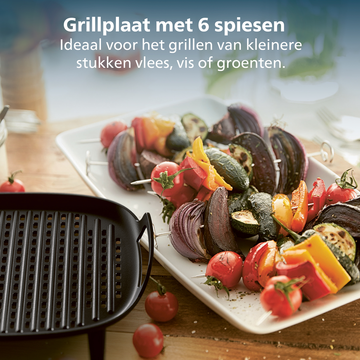 Une plaque de cuisson avec des brochettes de légumes grillés : tomates, poivrons, courgettes et oignons, sur une assiette blanche. Table en bois.
